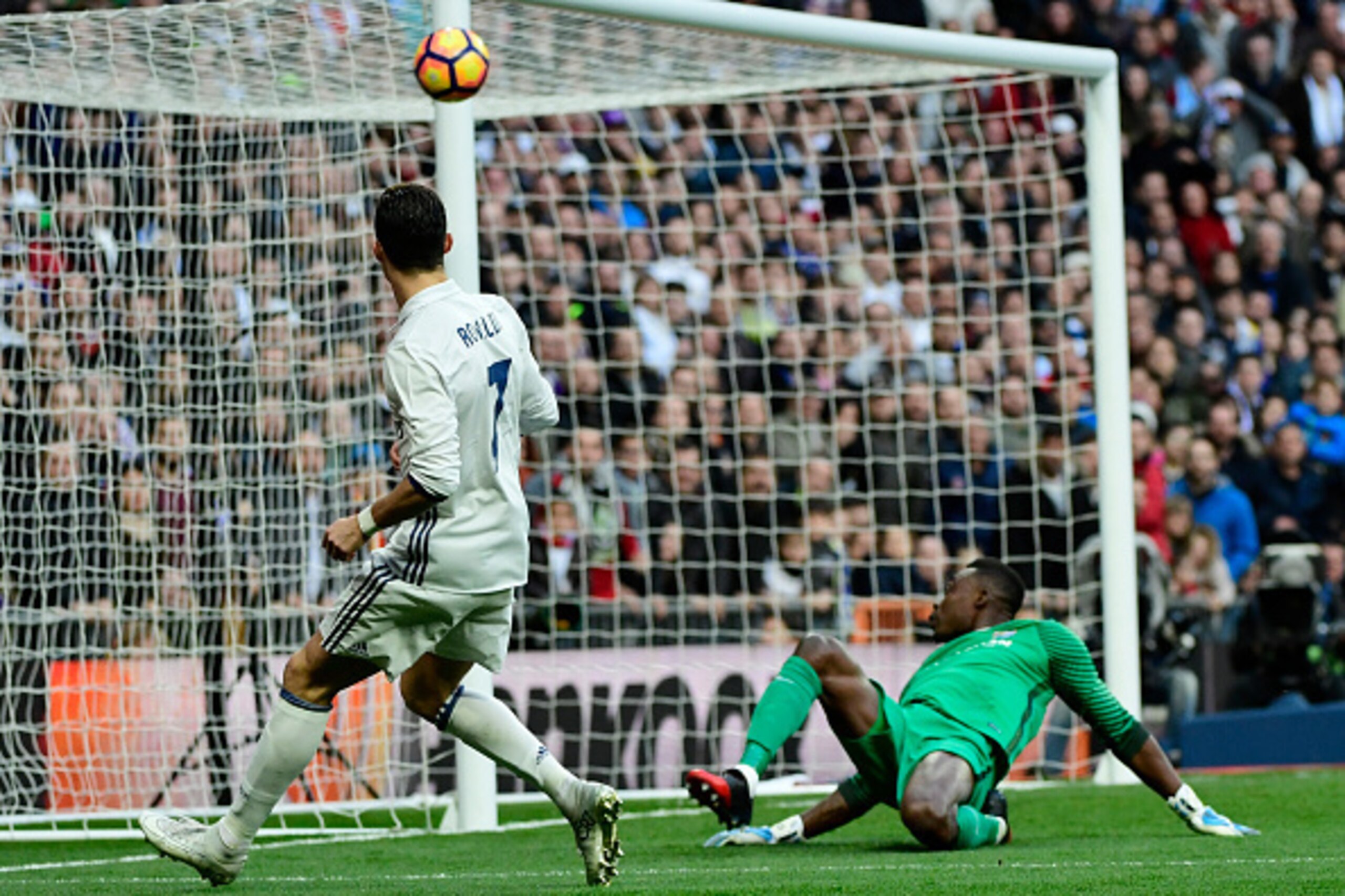Real Madrid's Portuguese forward Cristiano Ronaldo (L) kicks the ball towards Malaga's Cameroonian goalkeeper Idriss Kameni during the Spanish league football match Real Madrid CF vs Malaga CF at the Santiago Bernabeu stadium in Madrid on January 21, 2017