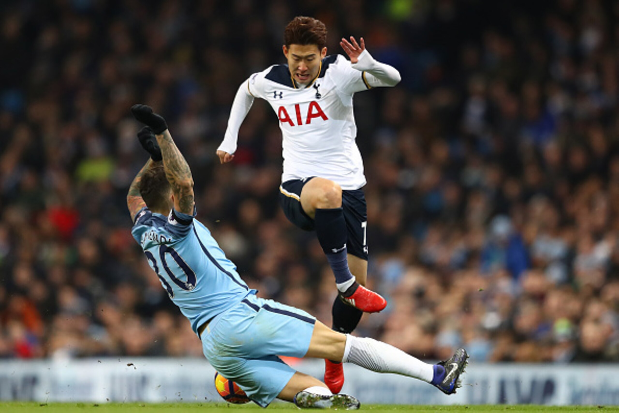MANCHESTER, ENGLAND - JANUARY 21: Nicolas Otamendi of Manchester City (L) tackles Heung-Min Son of Tottenham Hotspur (R) during the Premier League match between Manchester City and Tottenham Hotspur at the Etihad Stadium on January 21, 2017 in Manchester,