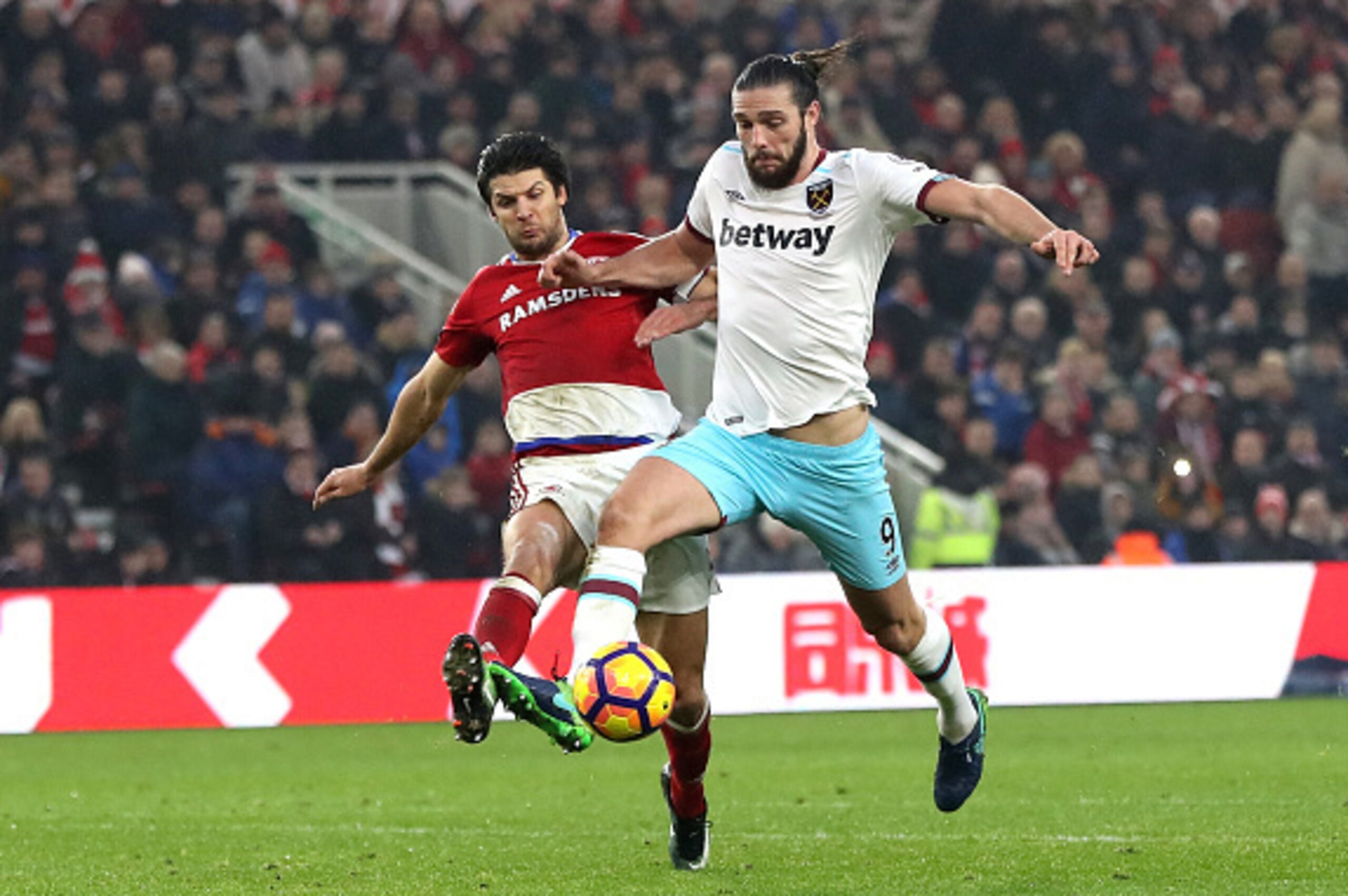 MIDDLESBROUGH, ENGLAND - JANUARY 21: George Friend of Middlesbrough (L) attempts to tackle Andy Carroll of West Ham United (R) during the Premier League match between Middlesbrough and West Ham United at the Riverside Stadium on January 21, 2017 in Middle