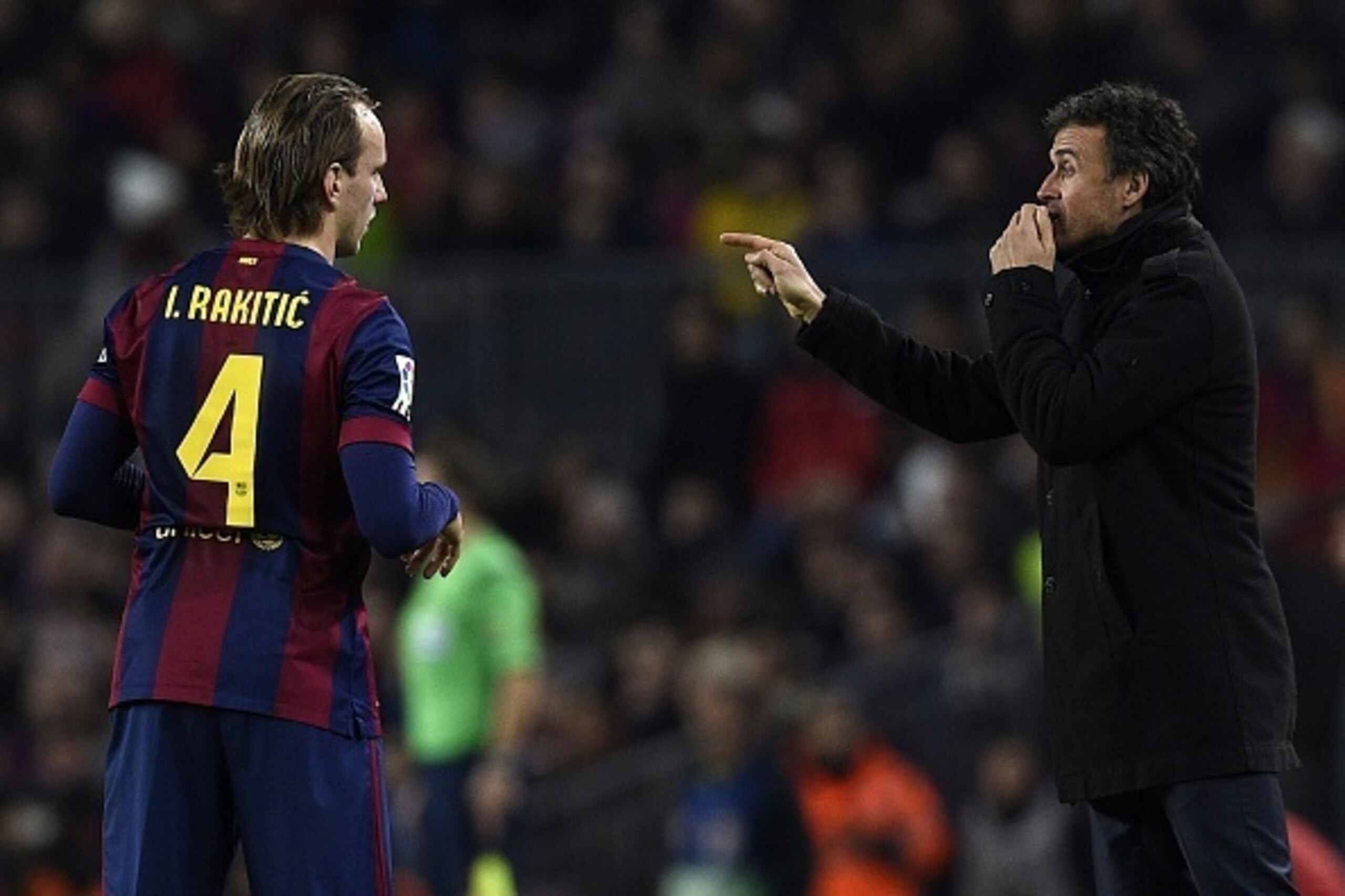 Barcelona's coach Luis Enrique talks wth Barcelona's Croatian midfielder Ivan Rakitic during the Spanish league football match FC Barcelona vs Club Atletico de Madrid at the Camp Nou stadium in Barcelona on January 11, 2015.   AFP PHOTO/ LLUIS GENE       