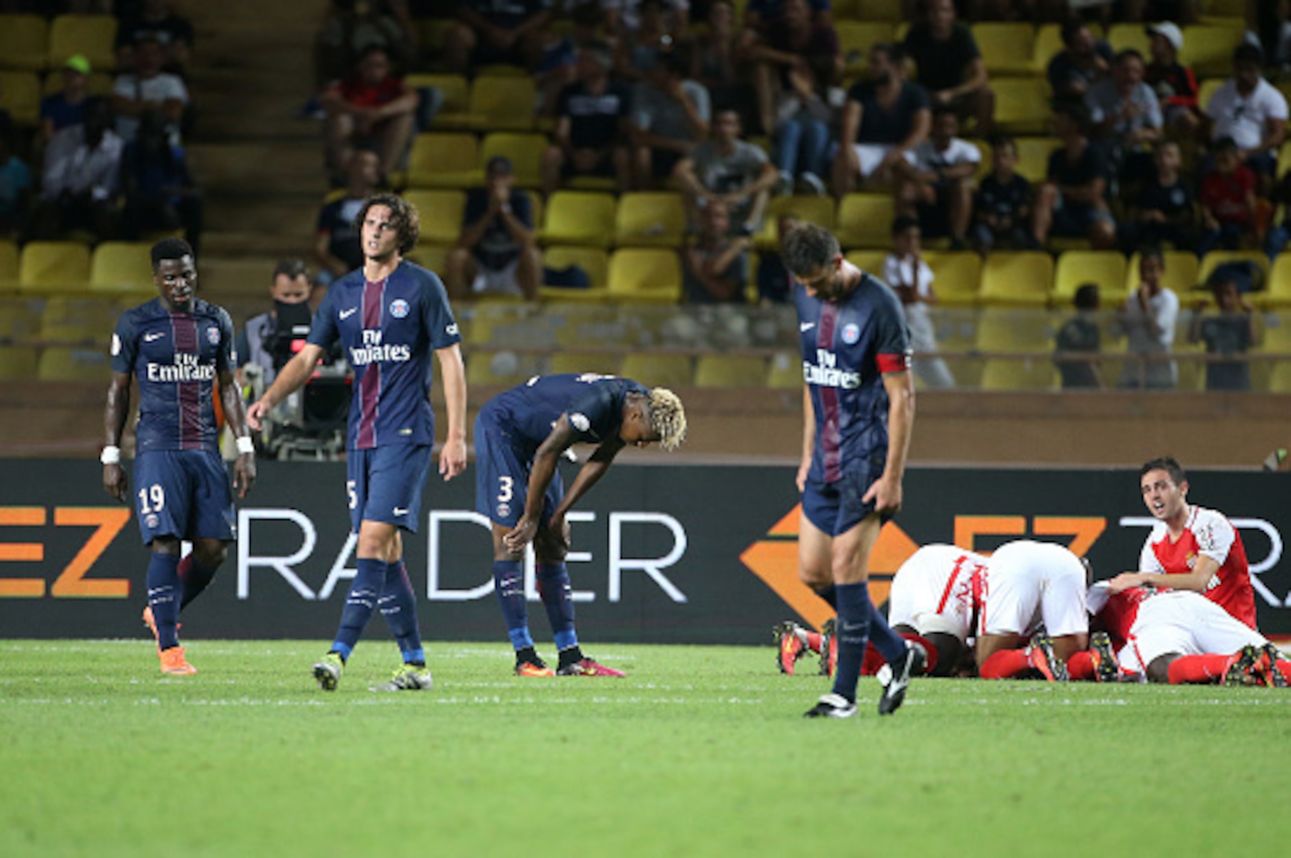 MONACO, MONACO - AUGUST 28: Players of Monaco celebrate their third goal while Serge Aurier, Adrien Rabiot, Presnel Kimpembe, Thiago Motta of PSG look down during the French Ligue 1 match between AS Monaco (ASM) and Paris Saint-Germain (PSG) at Stade Loui