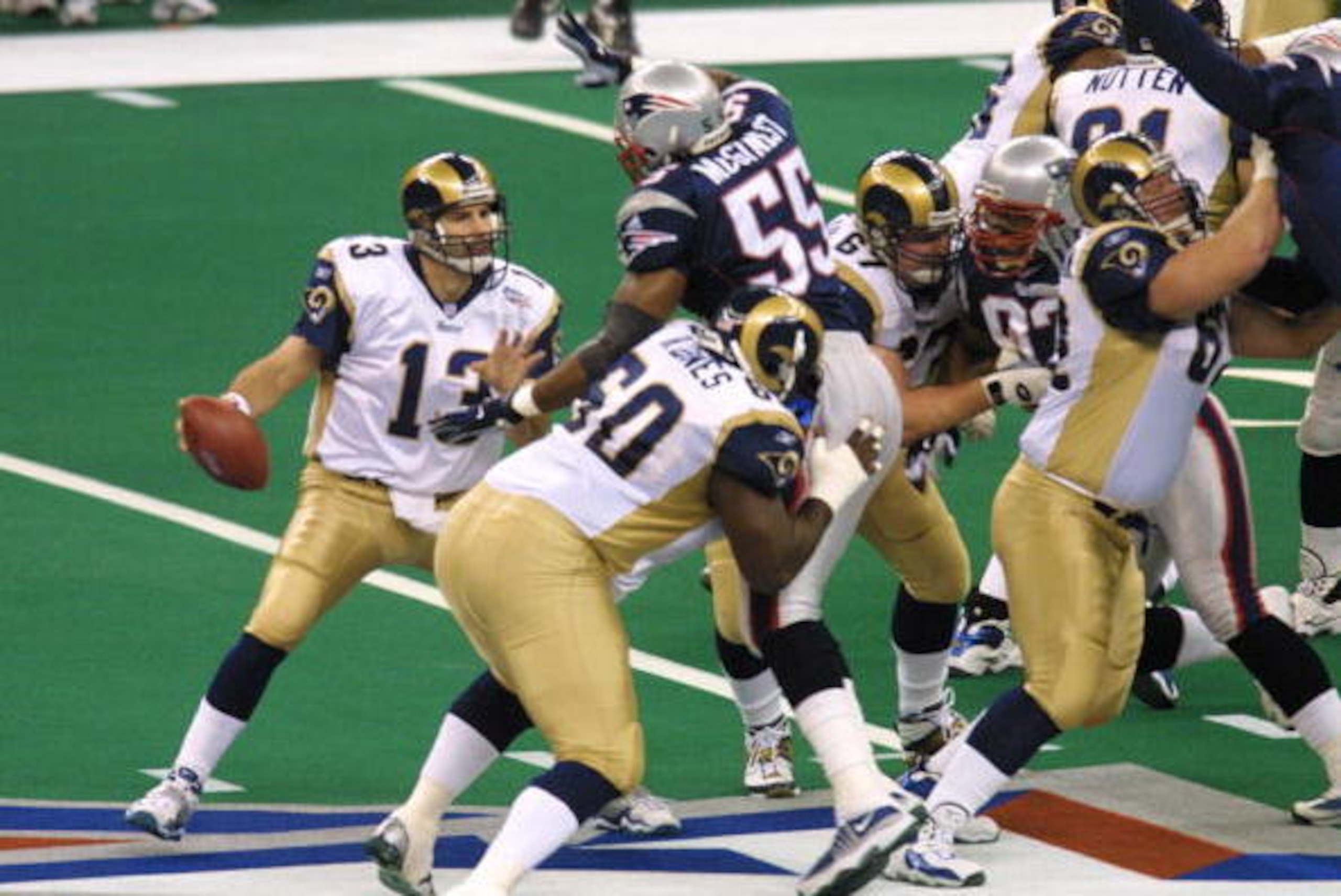 3 Feb 2002:  Quarterback Kurt Warner #13 of the St. Louis Rams scrambles in the pocket as defensive end Willie McGinest tries to get to him during Super Bowl XXXVI between the New England Patriots and the St. Louis Rams at the Superdome in New Orleans, Lo