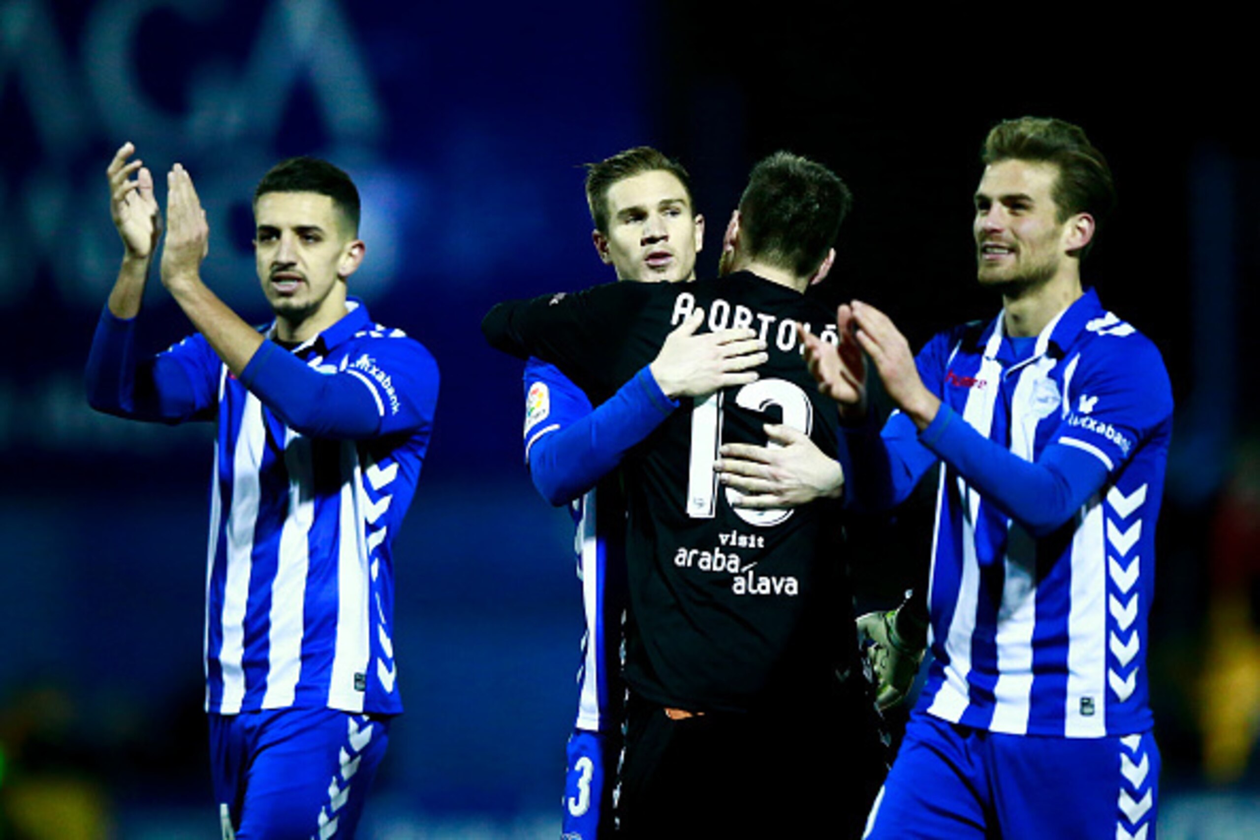 ALCORCON, SPAIN - JANUARY 18:  Raul Garcia (2ndL) of Deportivo Alaves hugs his teammate goalkeeper Adrian Ortola (2R) surrounded by Zouhair Feddal (L) and Christian Santos (R) after winnig the Copa del Rey quarter-final match between Agrupacion Deportivo 