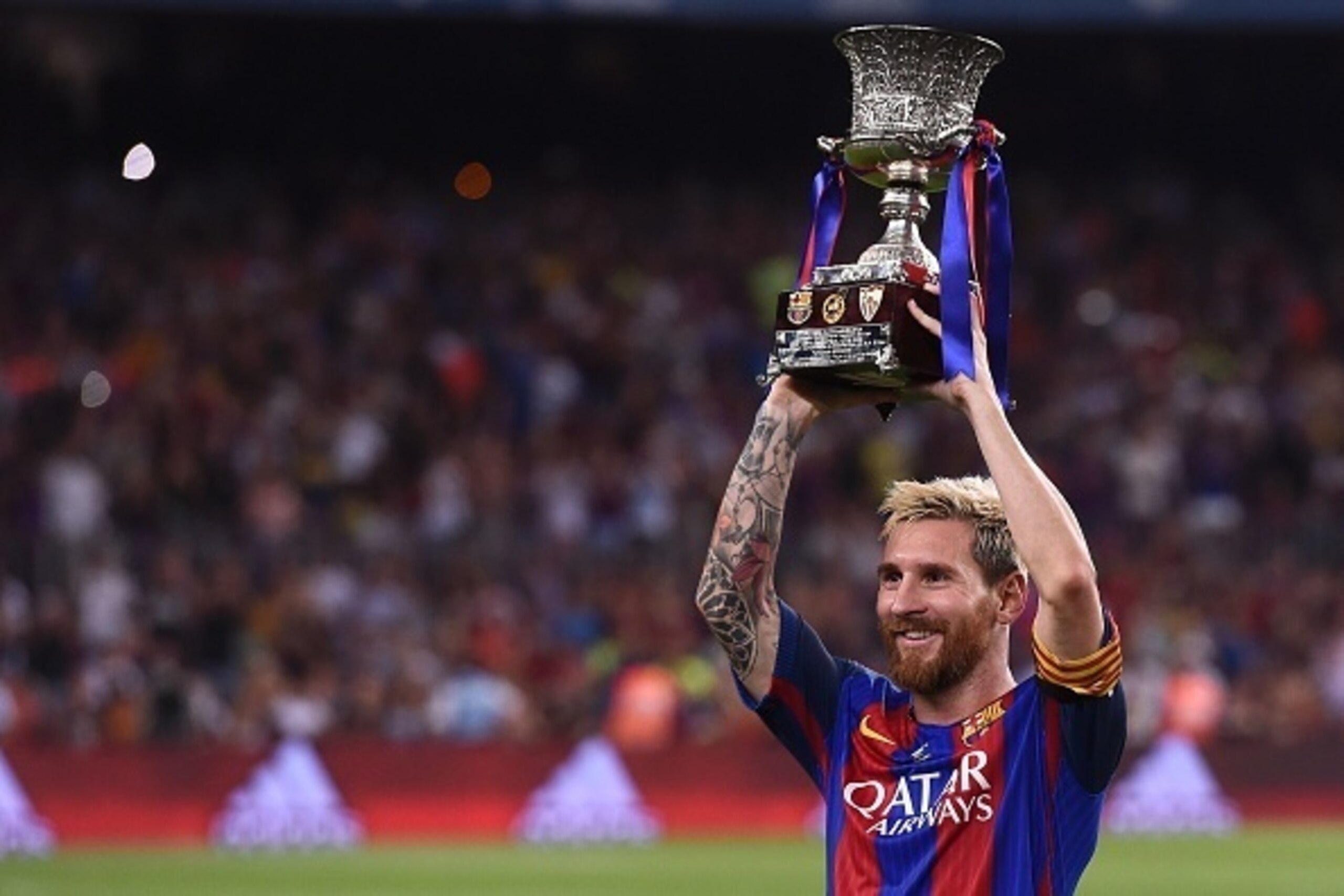 Barcelona's Argentinian forward Lionel Messi holds the Spanish Supercup trophy after winning  after winning the second leg of the Spanish Supercup football match between FC Barcelona and Sevilla FC at the Camp Nou stadium in Barcelona on August 17, 2016. 