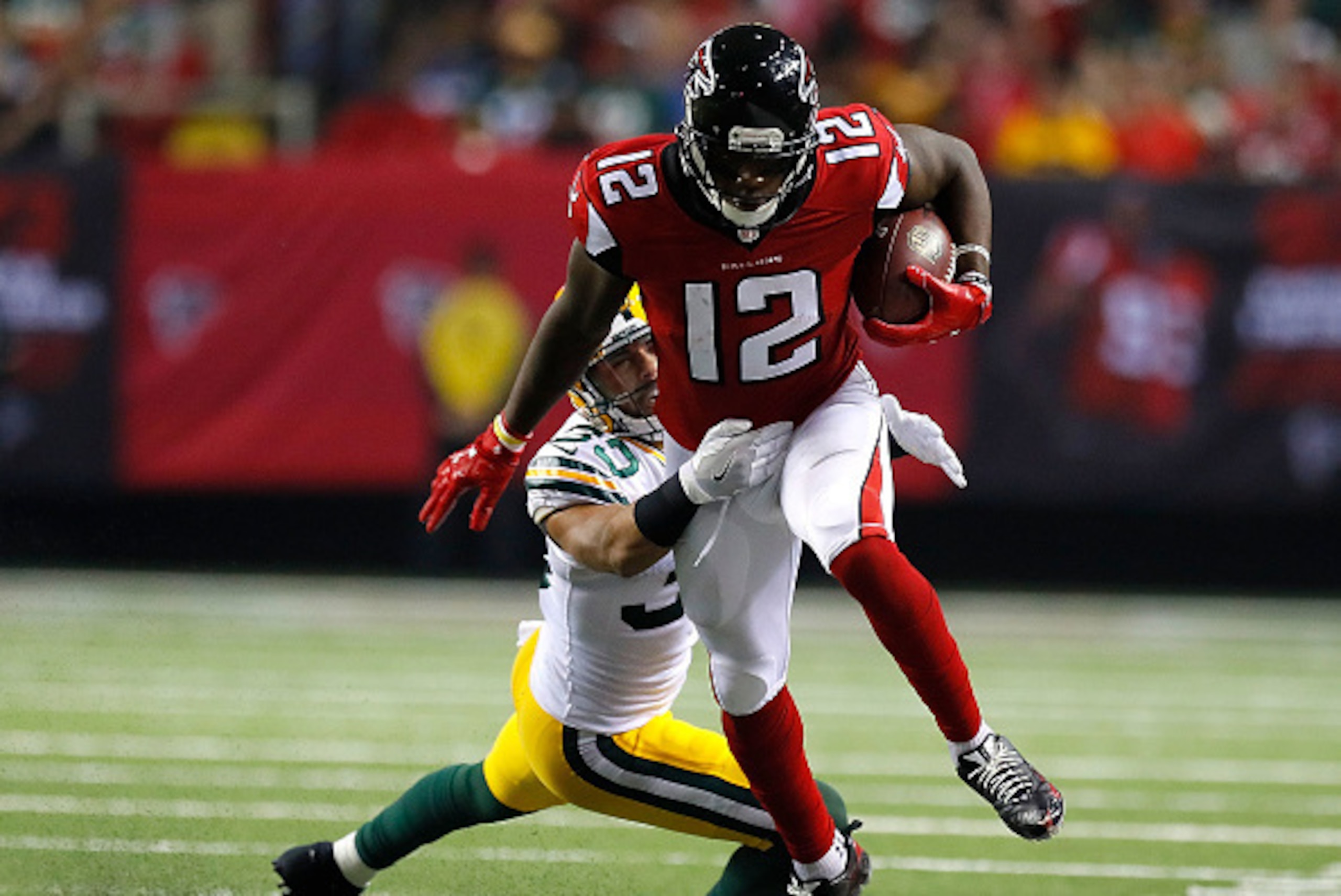 ATLANTA, GA - OCTOBER 30:  Mohamed Sanu #12 of the Atlanta Falcons attempts to break a tackle by Micah Hyde #33 of the Green Bay Packers at Georgia Dome on October 30, 2016 in Atlanta, Georgia.  (Photo by Kevin C. Cox/Getty Images)