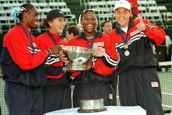 PALO ALTO, UNITED STATES:  Lindsay Davenport (R) gives a thumbs up as teammates, (L-R) Venus Williams, Monica Seles, and Serena Williams of the USA pose after receiving the Fed Cup trophy during the Federation Cup 19 September, 1999, at Stanford Universit