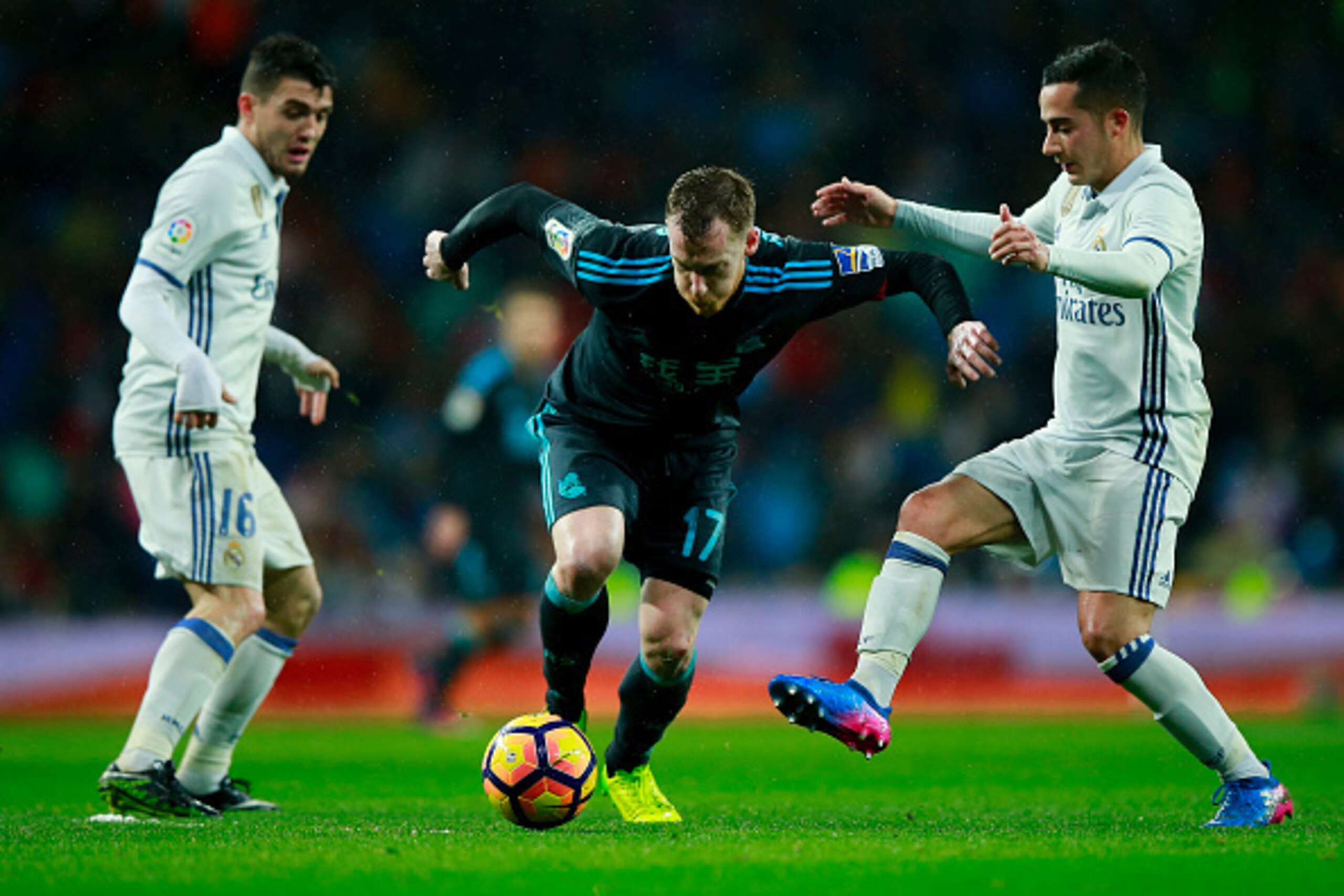 MADRID, SPAIN - JANUARY 29: David Zurutuza (2ndL) of Real Sociedad de Futbol competes for the ball with Mateo Kovacic (L) of Real Madrid CF and his teammate Lucas Vazquez (R) during the La Liga match between Real Madrid CF and Real Sociedad de Futbol at E