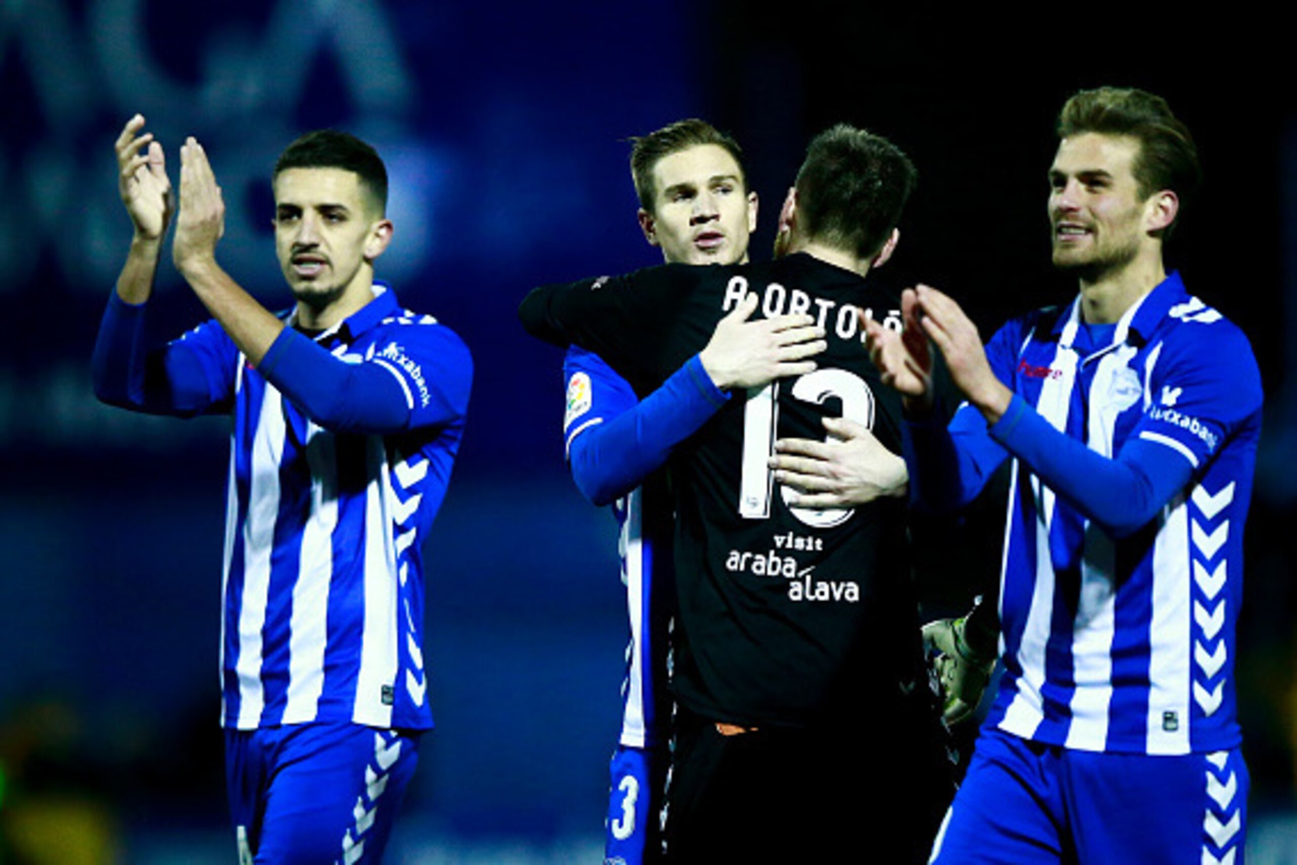 ALCORCON, SPAIN - JANUARY 18:  Raul Garcia (2ndL) of Deportivo Alaves hugs his teammate goalkeeper Adrian Ortola (2R) surrounded by Zouhair Feddal (L) and Christian Santos (R) after winnig the Copa del Rey quarter-final match between Agrupacion Deportivo 