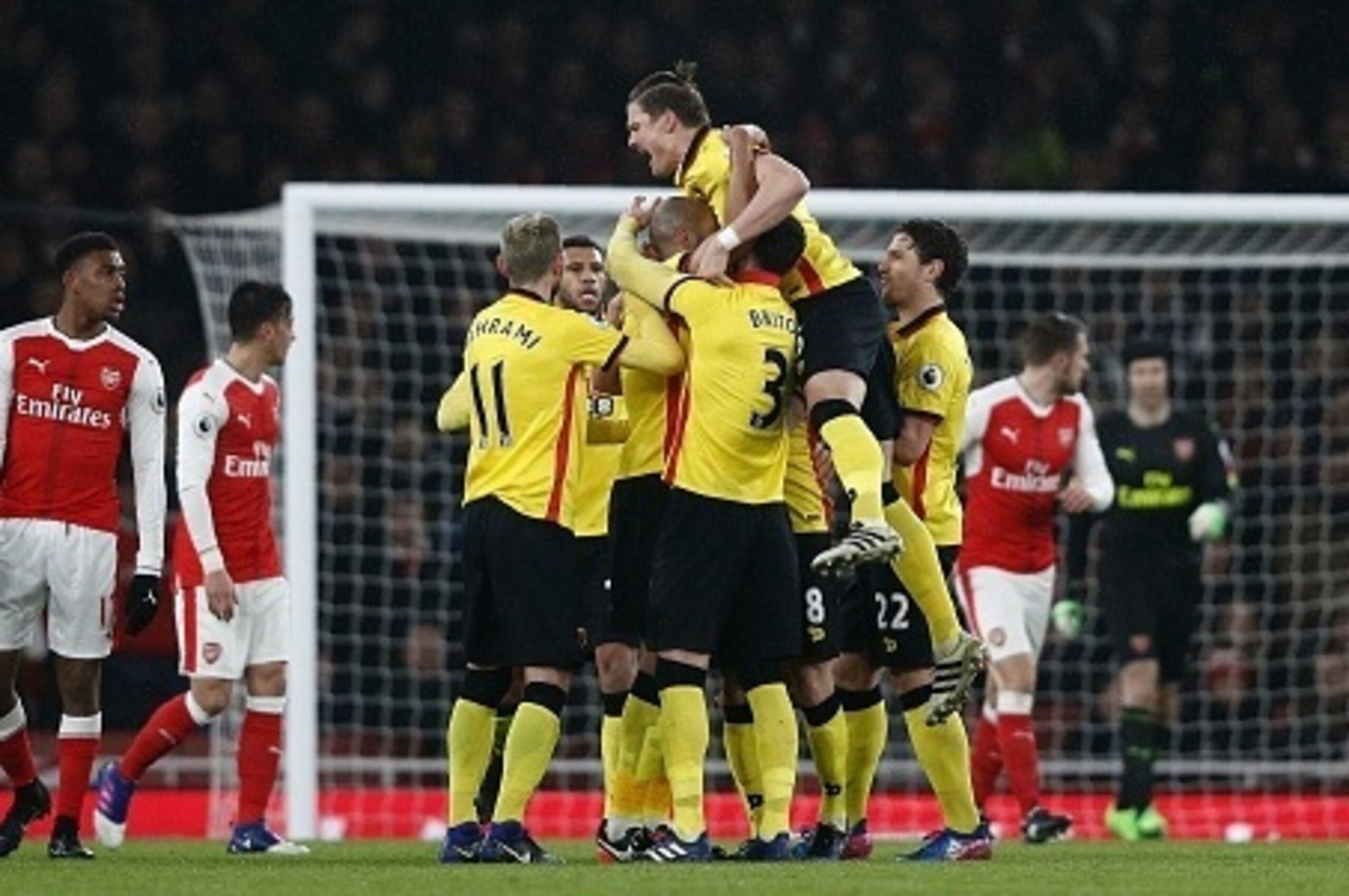 Watford's French midfielder Younes Kaboul (unseen) is mobbed by teammates as he celebrates scoring his team's first goal during the English Premier League football match between Arsenal and Watford at the Emirates Stadium in London on January 31, 2017. 
W