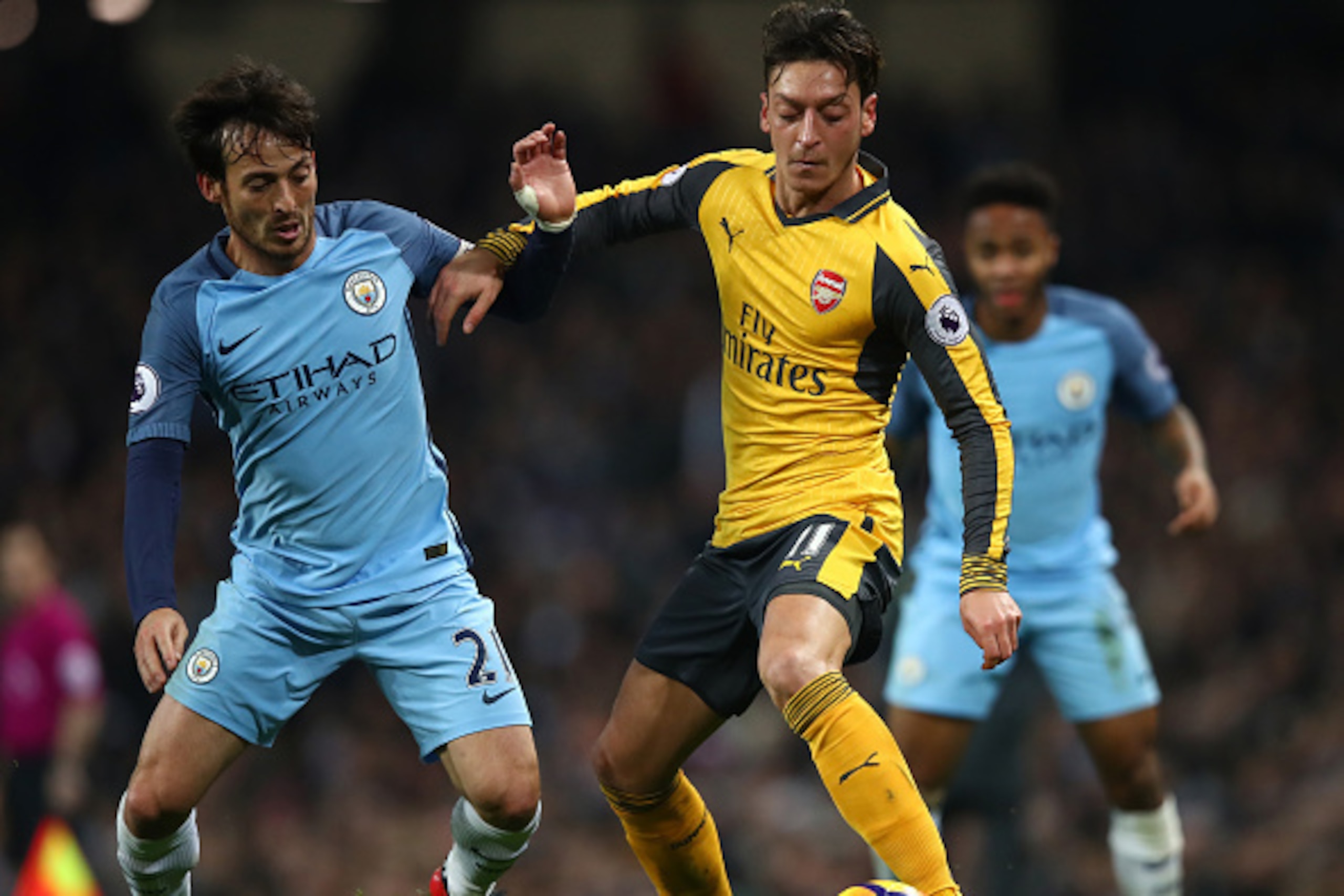 MANCHESTER, ENGLAND - DECEMBER 18: David Silva of Manchester City (L) and Mesut Ozil of Arsenal (R) battle for possession during the Premier League match between Manchester City and Arsenal at the Etihad Stadium on December 18, 2016 in Manchester, England