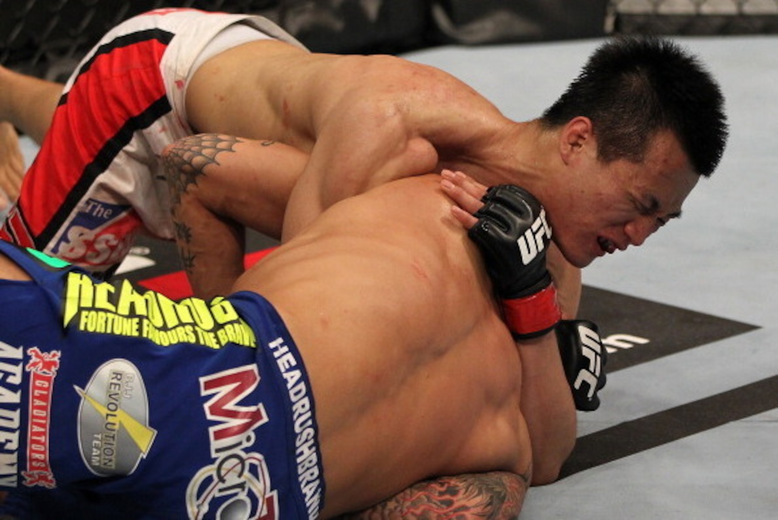 FAIRFAX, VA - MAY 15:  (L-R) 'The Korean Zombie' Chan Sung Jung defeats Dustin Poirier with a d'arce choke submission in a featherweight bout during the UFC on Fuel TV event at Patriot Center on May 15, 2012 in Fairfax, Virginia.  (Photo by Josh Hedges/Zu