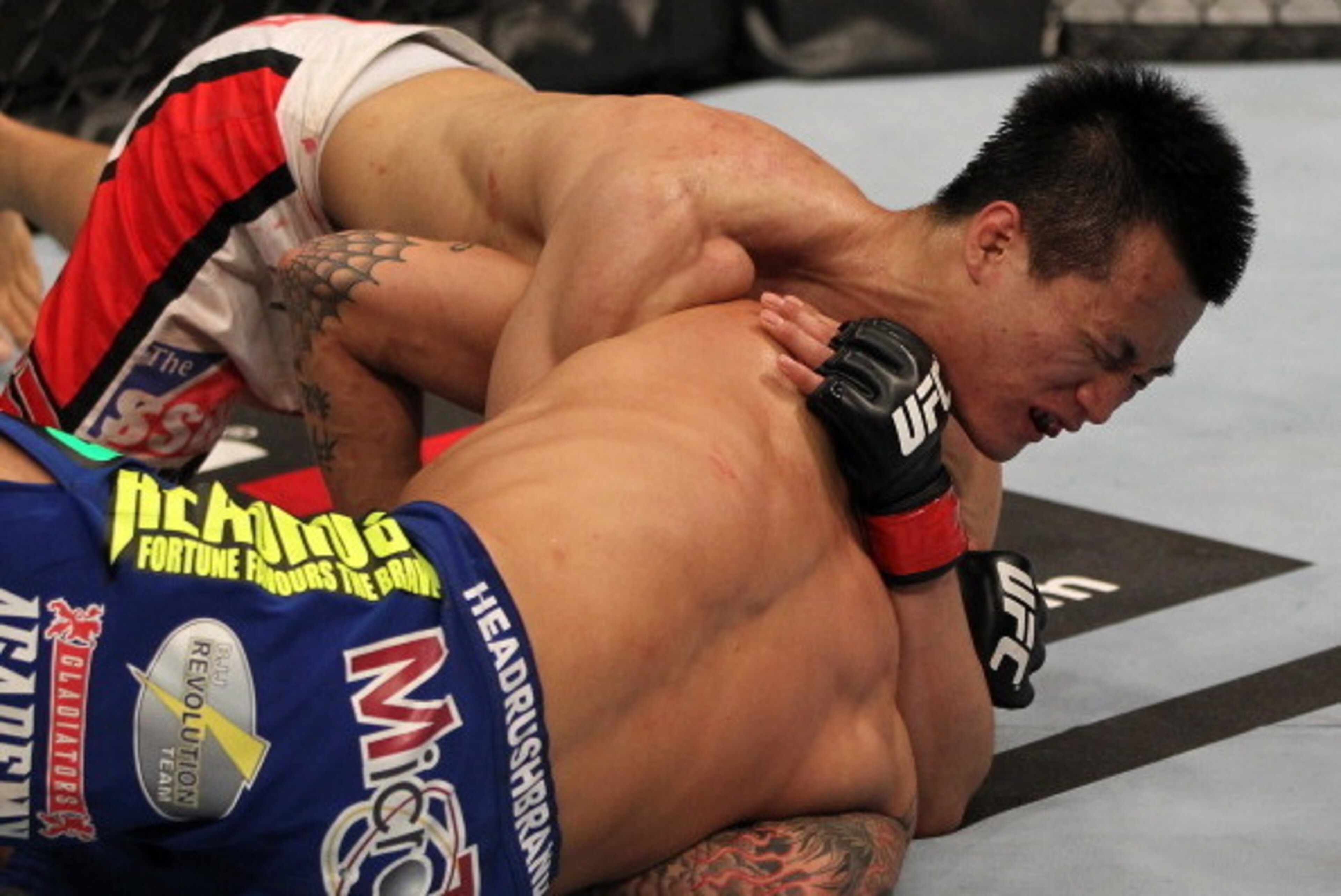 FAIRFAX, VA - MAY 15:  (L-R) 'The Korean Zombie' Chan Sung Jung defeats Dustin Poirier with a d'arce choke submission in a featherweight bout during the UFC on Fuel TV event at Patriot Center on May 15, 2012 in Fairfax, Virginia.  (Photo by Josh Hedges/Zu