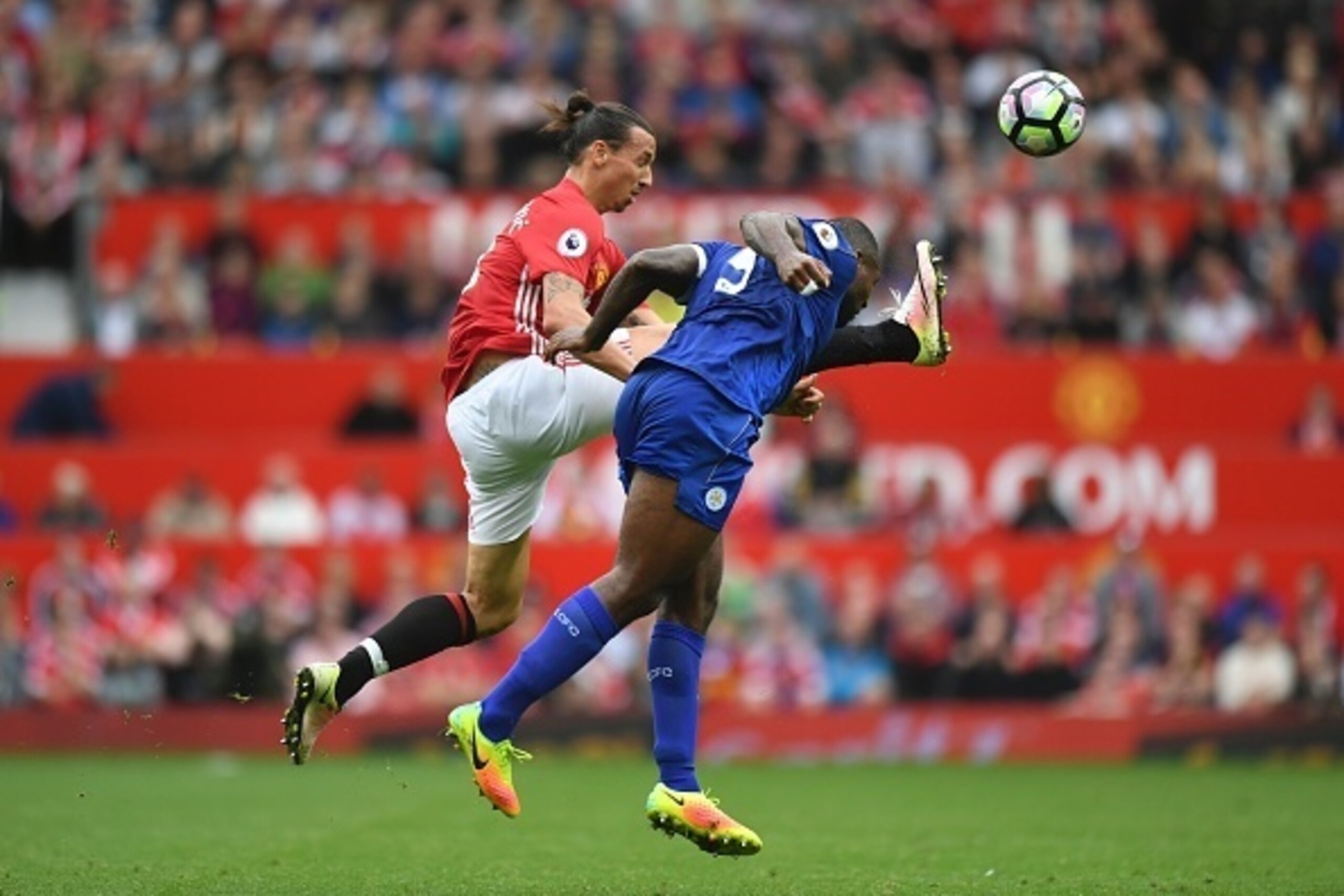 Manchester United's Swedish striker Zlatan Ibrahimovic (L) tries to win the ball against Leicester City's English-born Jamaican defender Wes Morgan (R) during the English Premier League football match between Manchester United and Leicester City at Old Tr