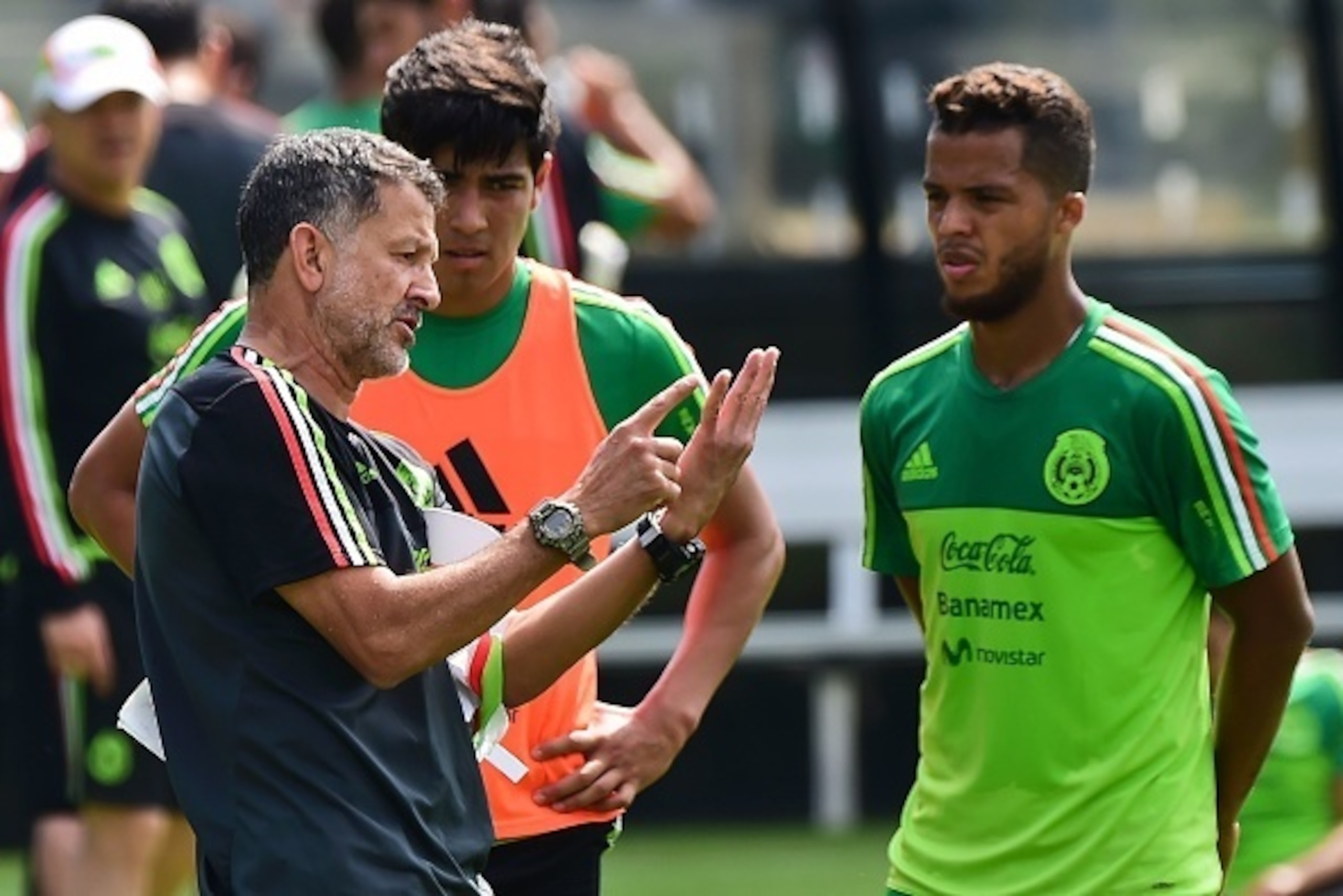 The coach of Mexico's national football team, Colombian Juan Carlos Osorio (L) speaks with Giovani dos Santos (R) during a training session in Mexico City on October 4, 2016 ahead of the upcoming international friendly matches against New Zealand and Pana