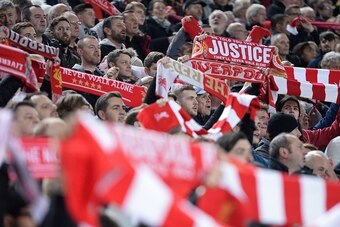 Liverpool supporters raise their scarves in the crowd during the EFL (English Football League) Cup fourth round match between Liverpool and Tottenham Hotspur at Anfield in Liverpool north west England on October 25, 2016. / AFP / Oli SCARFF / RESTRICTED T