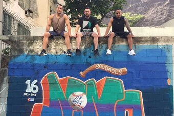 Stanton, Ramos and Nolasco sit atop the graffiti wall art they commissioned in Rio de Janeiro to honor Fernandez last fall.