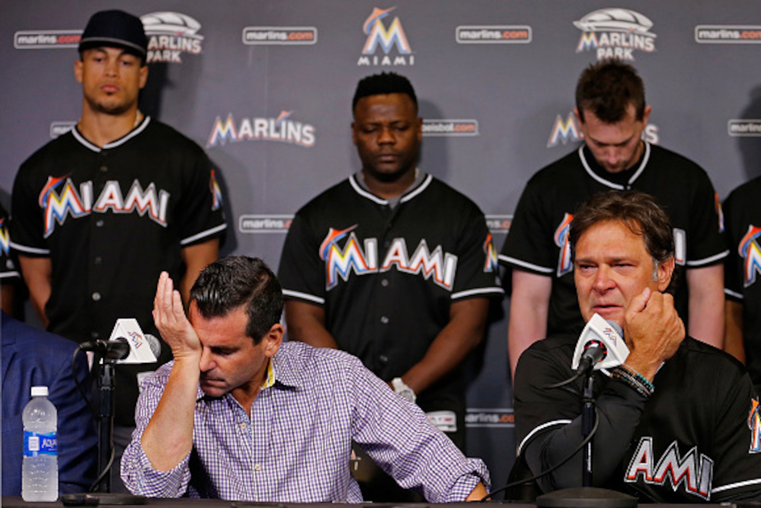 MIAMI, FL - SEPTEMBER 25:   Miami Marlins team president David Samson, front left, manager Don Mattingly (R) and players behind from left, Giancarlo Stanton, Fernando Rodney and Chris Johnson react during a press conference after pitcher Jose Fernanedez d