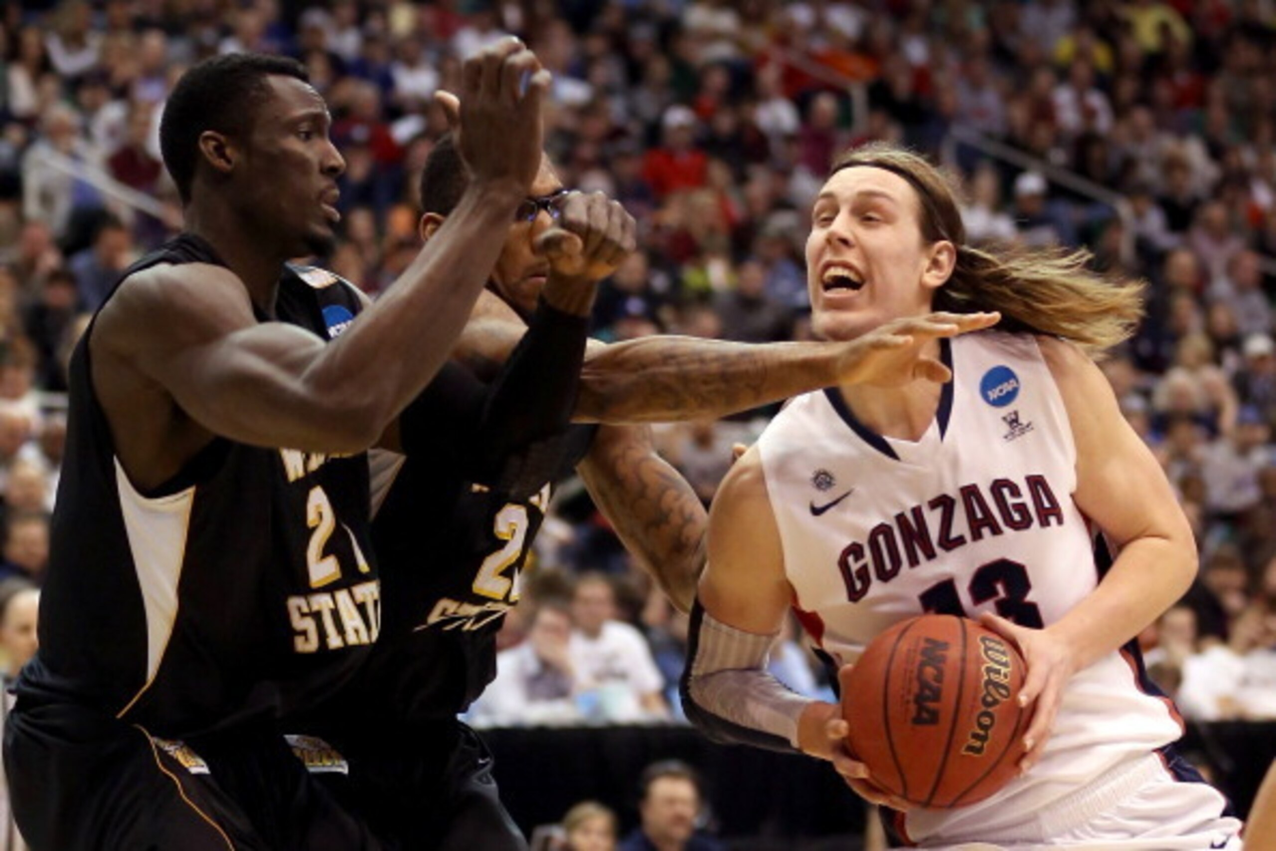 SALT LAKE CITY, UT - MARCH 23:  Kelly Olynyk #13 of the Gonzaga Bulldogs drives to the basket against Ehimen Orukpe #21 and Carl Hall #22 of the Wichita State Shockers in the first half during the third round of the 2013 NCAA Men's Basketball Tournament a