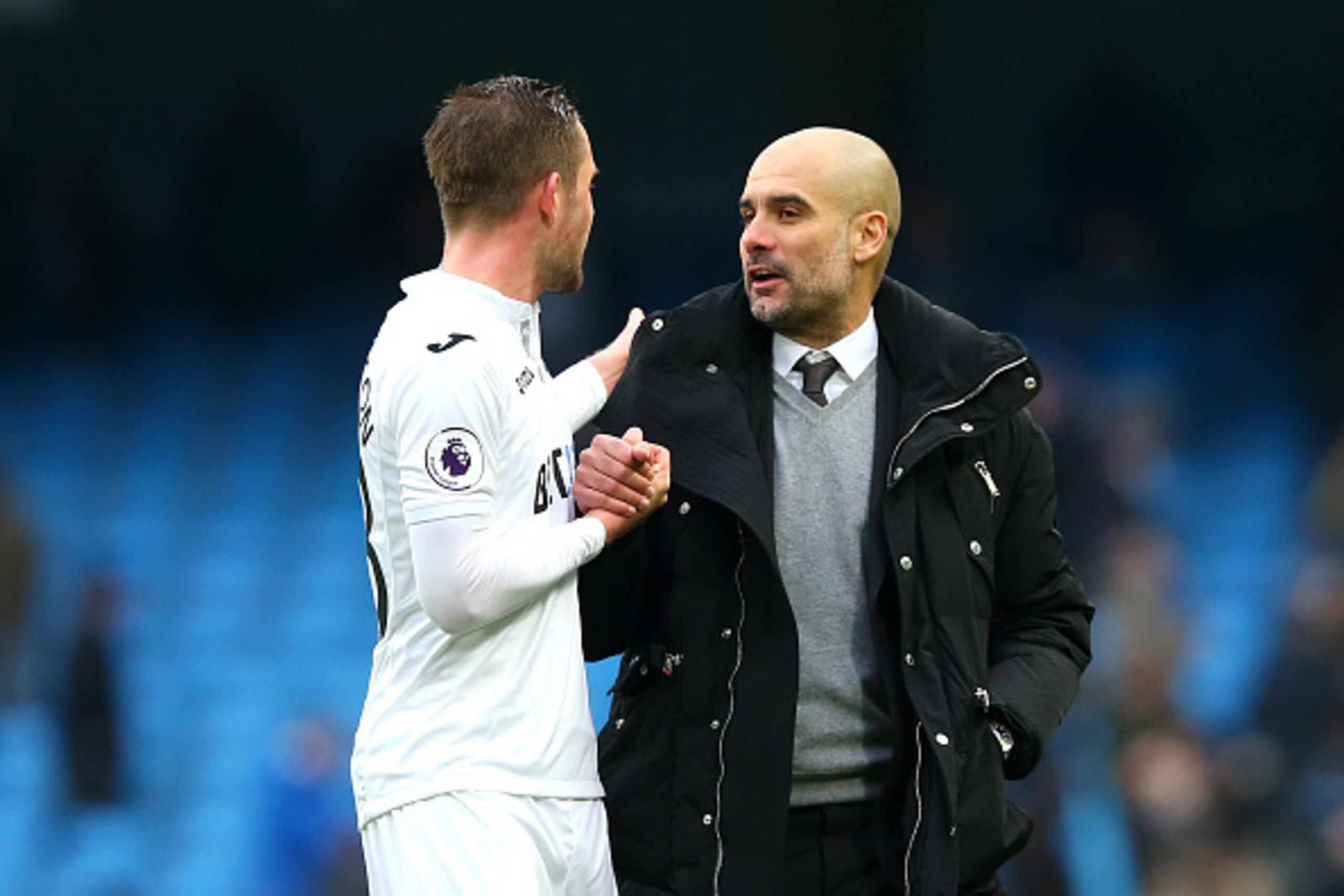 MANCHESTER, ENGLAND - FEBRUARY 05:  Josep Guardiola, Manager of Manchester City speaks with Gylfi Sigurdsson of Swansea City after the game during the Premier League match between Manchester City and Swansea City at Etihad Stadium on February 5, 2017 in M