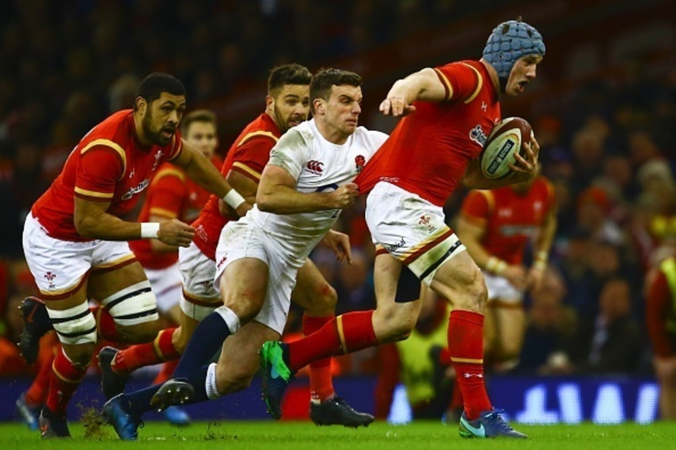 England's fly-half George Ford (2R) grabs Wales' center Jonathan Davies (R) during the Six Nations international rugby union match between Wales and England at the Principality Stadium in Cardiff, south Wales, on February 11, 2017. / AFP / Geoff CADDICK /