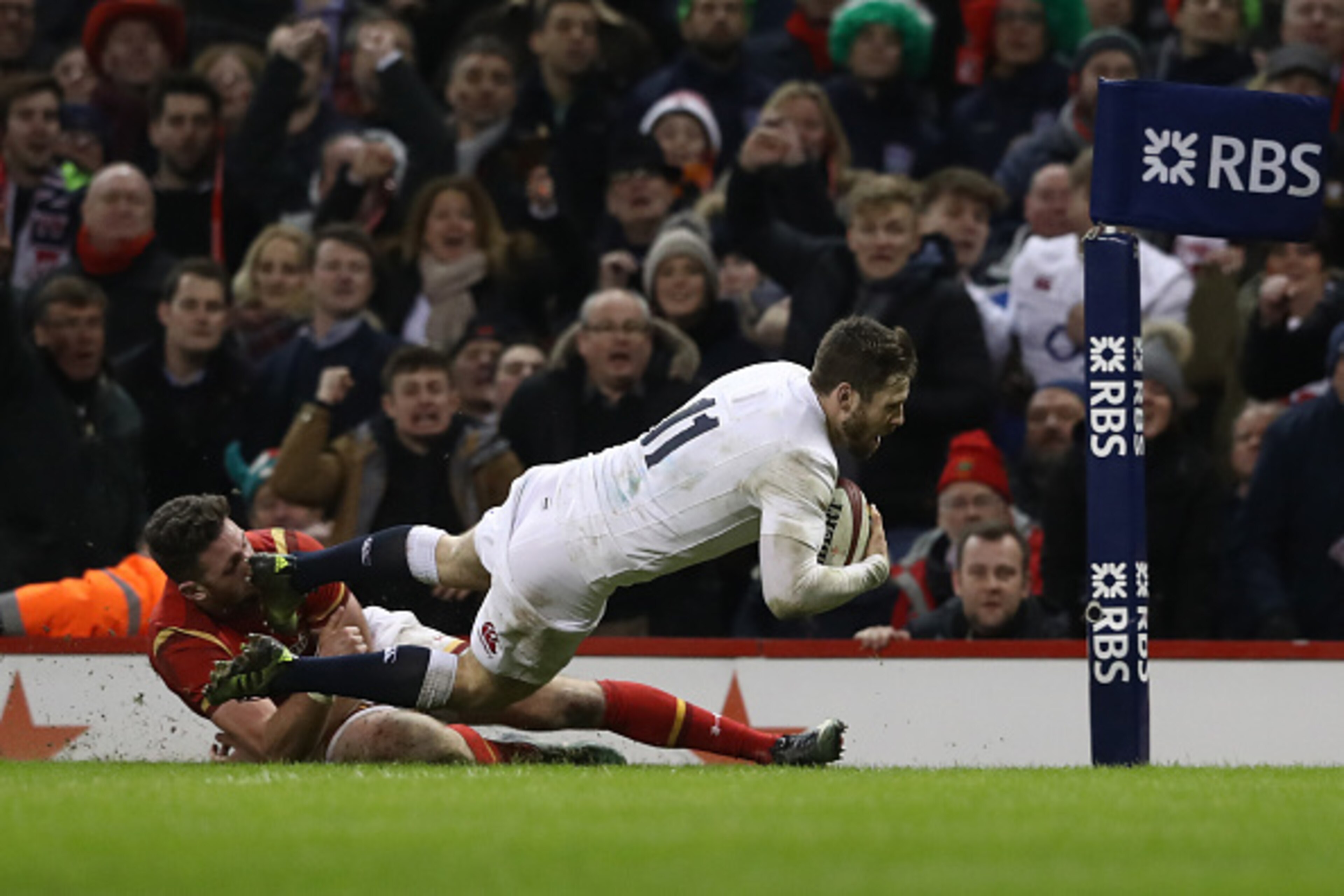 CARDIFF, WALES - FEBRUARY 11:  Elliot Daly of England dives past Alex Cuthbert of Wales to score the match winning try during the RBS Six Nations match between Wales and England at the Principality Stadium on February 11, 2017 in Cardiff, Wales.  (Photo b