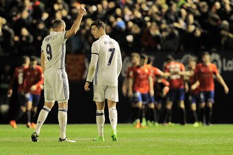 Real Madrid's French forward Karim Benzema (L) speaks with teammate Portuguese forward Cristiano Ronaldo (R) after a goal by Osasuna during the Spanish league football match CA Osasuna vs Real Madrid CF at El Sadar stadium in Pamplona on February 11, 2017