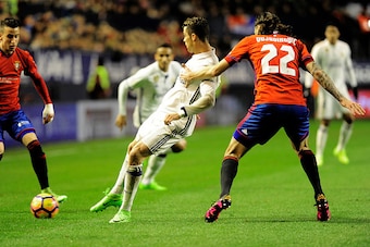 Real Madrid's Portuguese forward Cristiano Ronaldo (L) vies with Real Madrid's midfielder Francisco Roman (R) during the Spanish league football match CA Osasuna vs Real Madrid CF at El Sadar stadium in Pamplona on February 11, 2017. / AFP / ANDER GILLENE