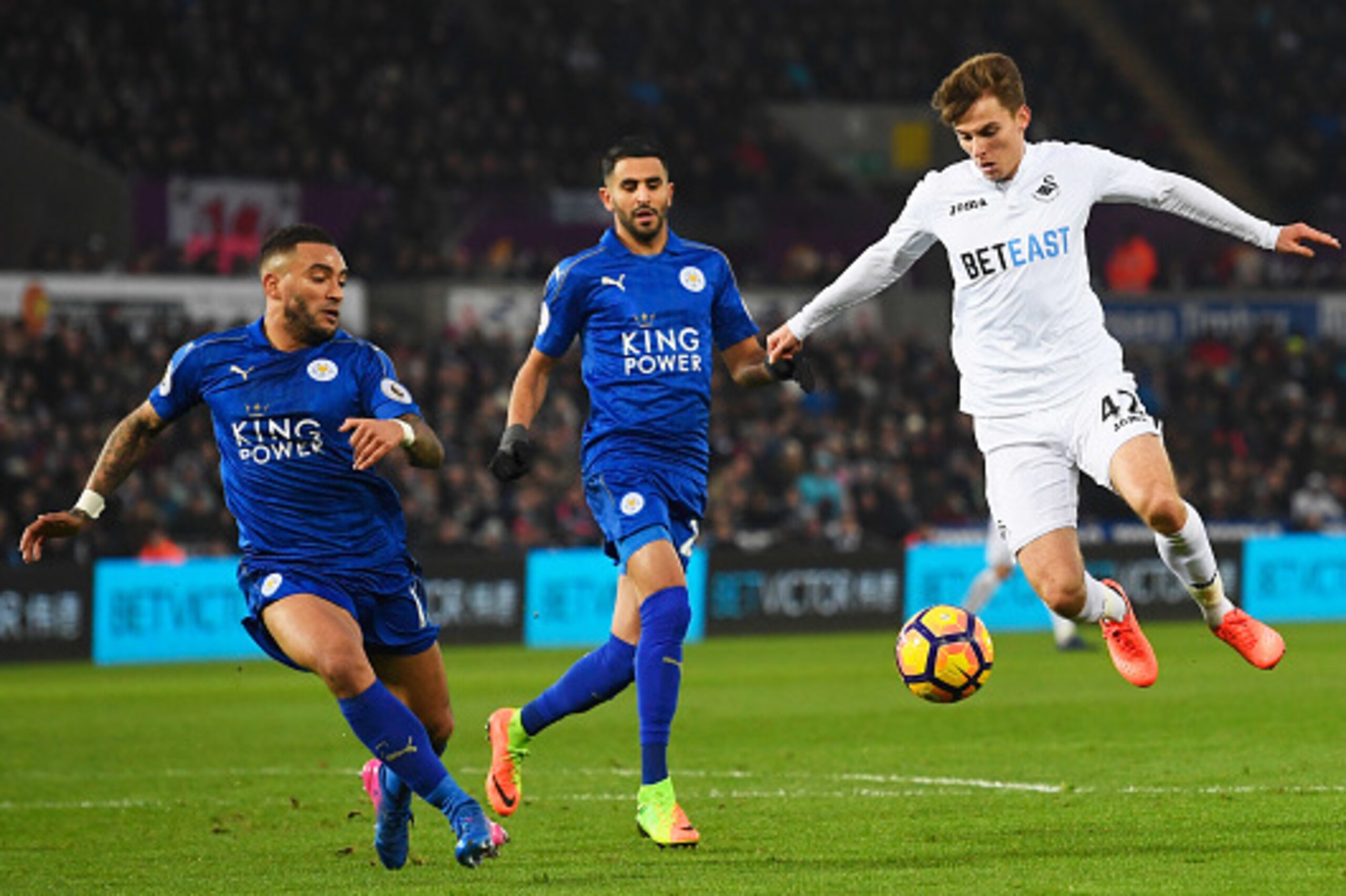 SWANSEA, WALES - FEBRUARY 12:  Tom Carroll of Swansea City takes on Danny Simpson and Riyad Mahrez of Leicester City during the Premier League match between Swansea City and Leicester City at Liberty Stadium on February 12, 2017 in Swansea, Wales.  (Photo
