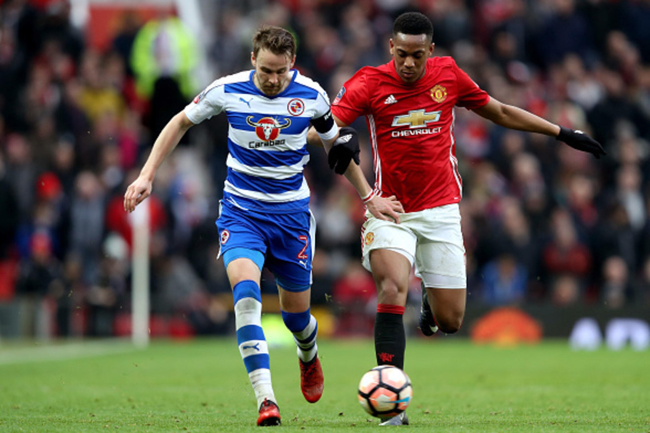 MANCHESTER, ENGLAND - JANUARY 07: Chris Gunter of Reading holds off Anthony Martial of Manchester United  during the Emirates FA Cup third round match between Manchester United and Reading at Old Trafford on January 7, 2017 in Manchester, England.  (Photo