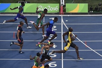 Jamaica's Usain Bolt (R) crosses the finish line ahead of USA's Justin Gatlin (3rd down) to win the Men's 100m Final during the athletics event at the Rio 2016 Olympic Games at the Olympic Stadium in Rio de Janeiro on August 14, 2016.   / AFP / John MACDO