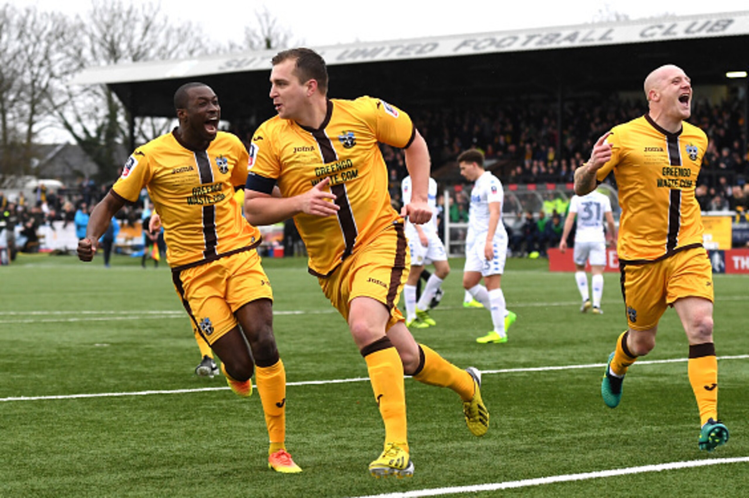 SUTTON, GREATER LONDON - JANUARY 29: Jamie Collins of Sutton United (C) celebrates scoring his sides first goal with his Sutton United team mates during The Emirates FA Cup Fourth Round match between Sutton United and Leeds United at Borough Sports Groun SUTTON, GREATER LONDON - JANUARY 29: Jamie Collins of Sutton United (C) celebrates scoring his sides first goal with his Sutton United team mates during The Emirates FA Cup Fourth Round match between Sutton United and Leeds United at Borough Sports Groun