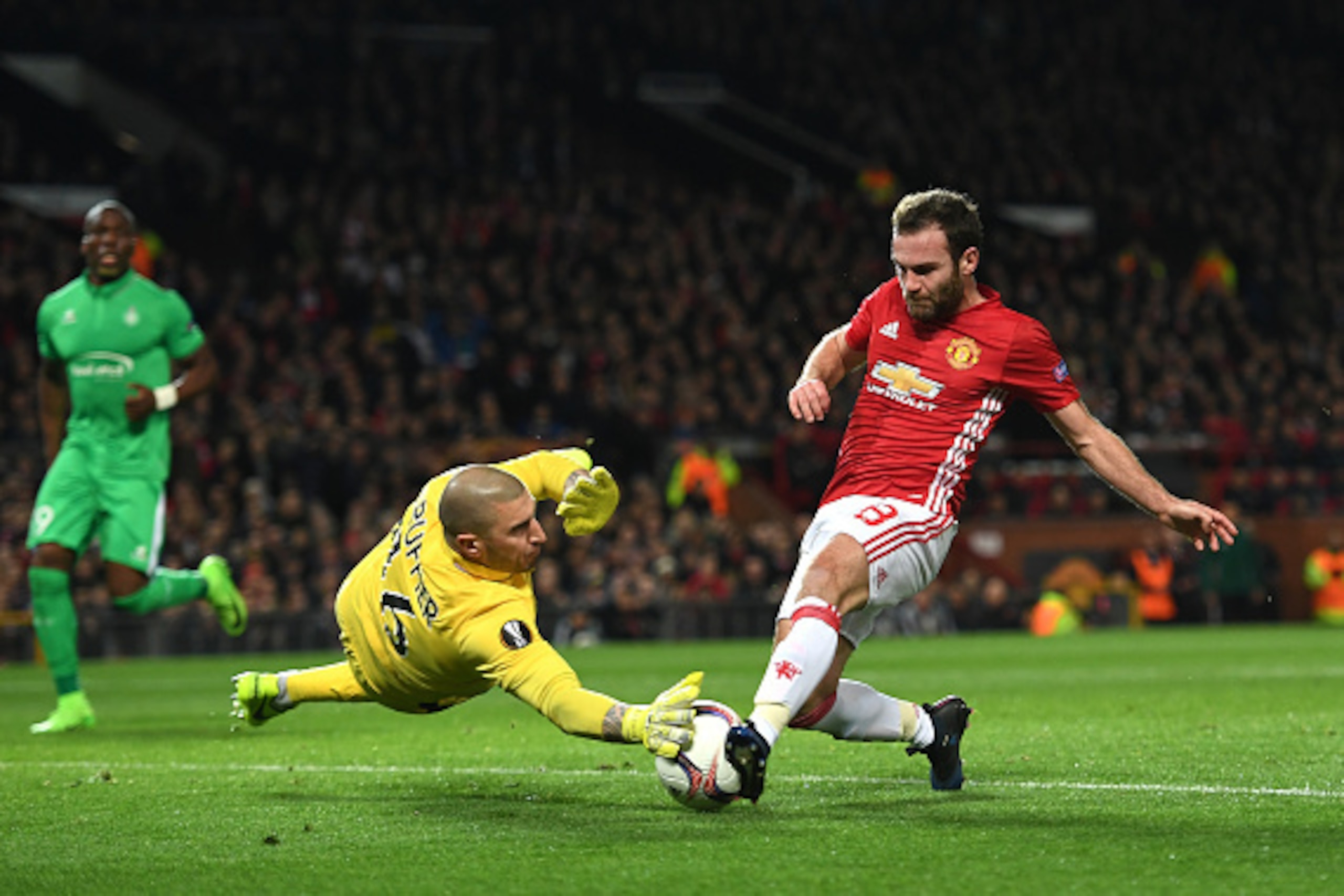 MANCHESTER, ENGLAND - FEBRUARY 16:  Stephane Ruffier of Saint-Etienne attempts to stop Juan Mata of Manchester United during the UEFA Europa  League Round of 32 first leg match between Manchester United and AS Saint-Etienne at Old Trafford on February 16,