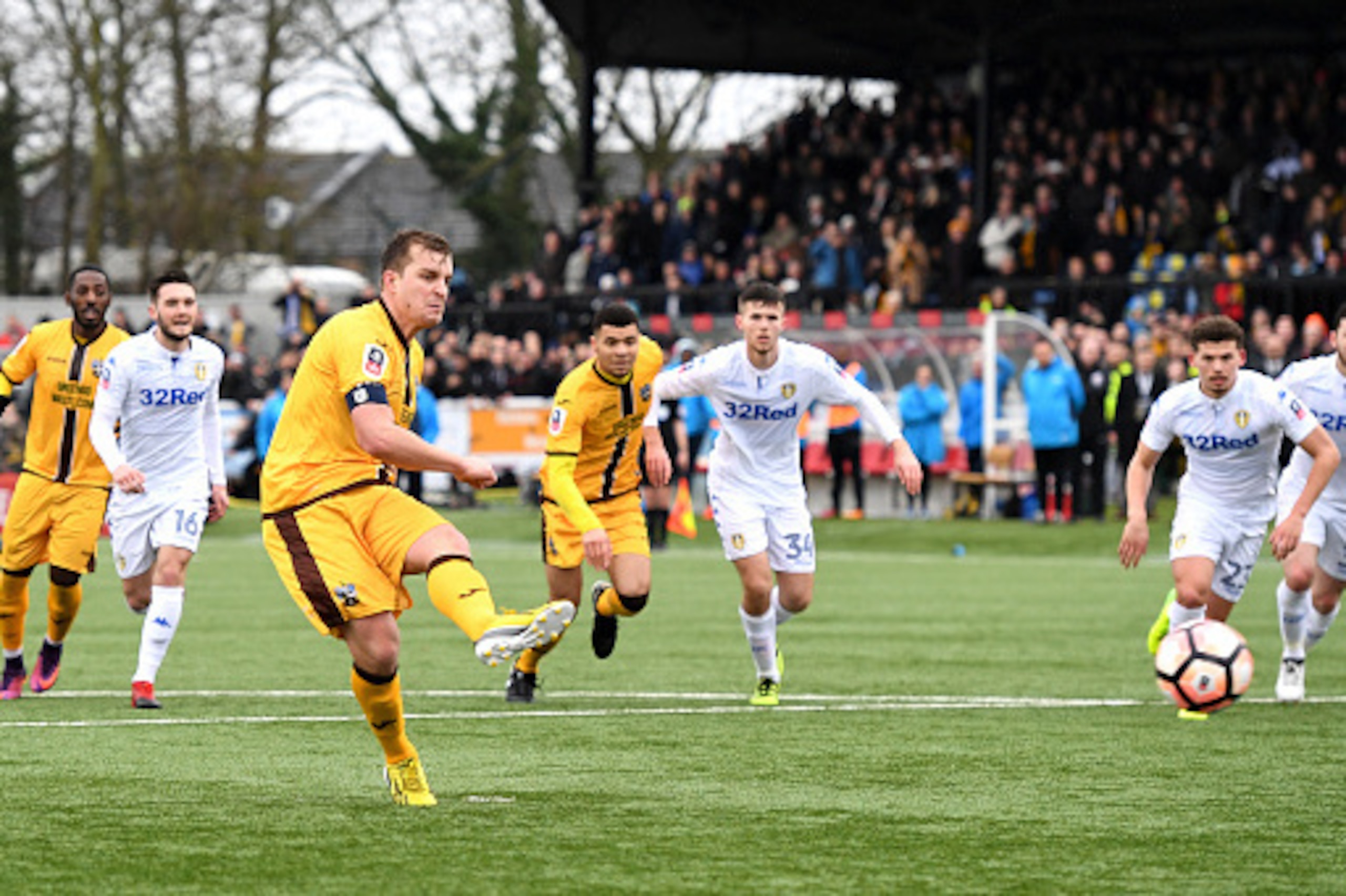 SUTTON, GREATER LONDON - JANUARY 29: Jamie Collins of Sutton United (L) scores his sides first goal from the penalty spot during The Emirates FA Cup Fourth Round match between Sutton United and Leeds United at Borough Sports Ground on January 29, 2017 in 