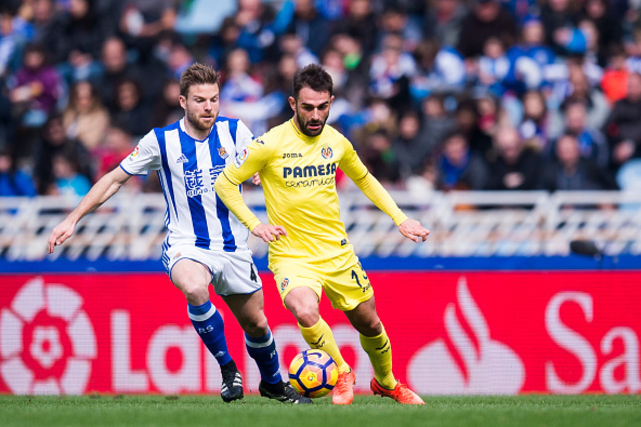 SAN SEBASTIAN, SPAIN - FEBRUARY 19:  Adrian Lopez of Villarreal CF duels for the ball with Asier Illarramendi of Real Sociedad during the La Liga match between Real Sociedad de Futbol and Villarreal CF at Estadio Anoeta on February 19, 2017 in San Sebasti