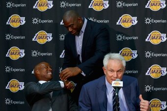 EL SEGUNDO, CA - JULY 29:  (L-R) Byron Scott shakes hands with Earvin 'Magic' Johnson, as Los Angeles Lakers general manager Mitch Kupchak addresses the media during a press conference to introduce Byron Scott as the new head coach of the Los Angeles Lake