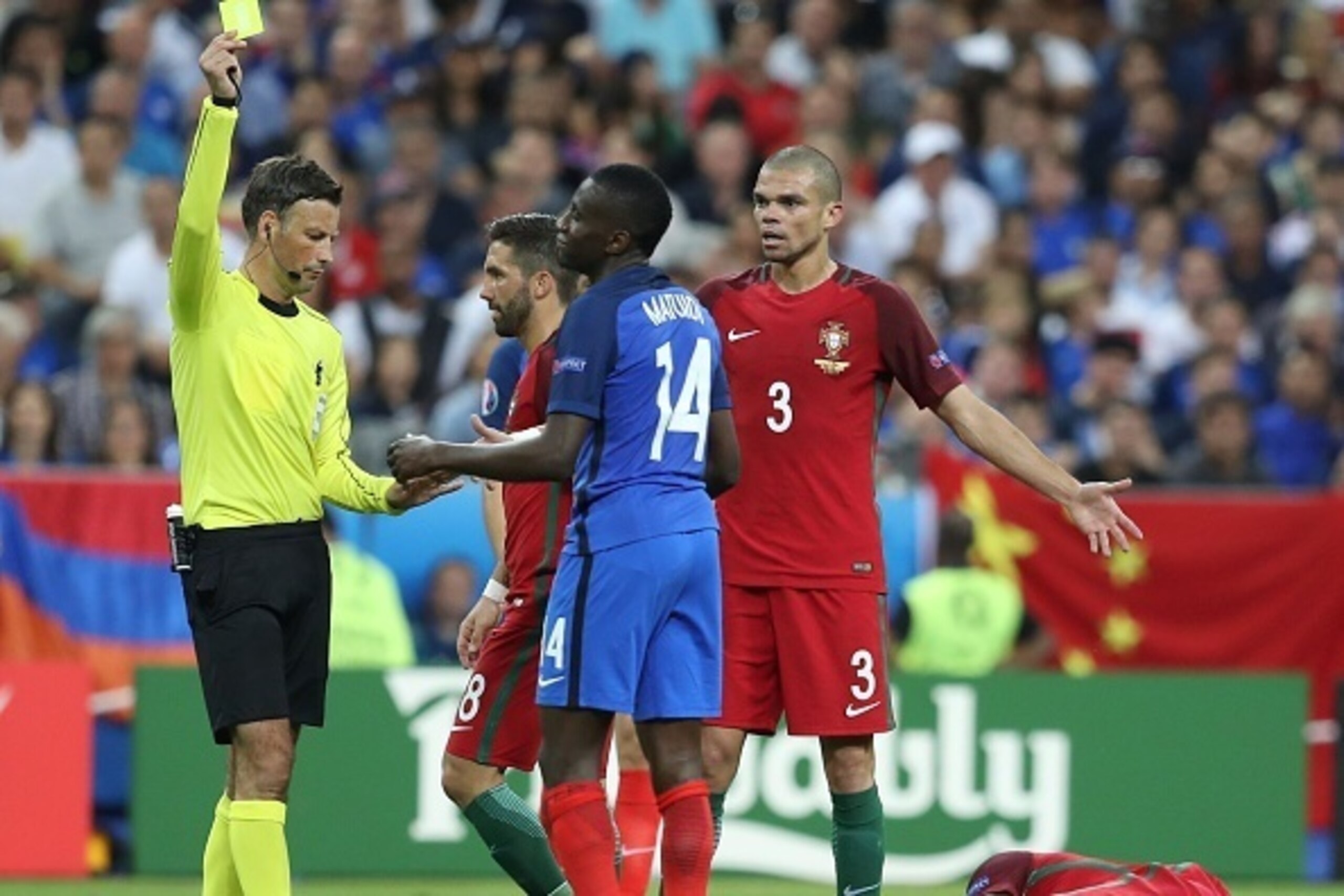 France's midfielder Blaise Matuidi (C) argues with English referee Mark Clattenburg (L) as he receives a yellow card after colliding with Portugal's forward Eder (R) during the Euro 2016 final football match between Portugal and France at the Stade de Fra France's midfielder Blaise Matuidi (C) argues with English referee Mark Clattenburg (L) as he receives a yellow card after colliding with Portugal's forward Eder (R) during the Euro 2016 final football match between Portugal and France at the Stade de Fra