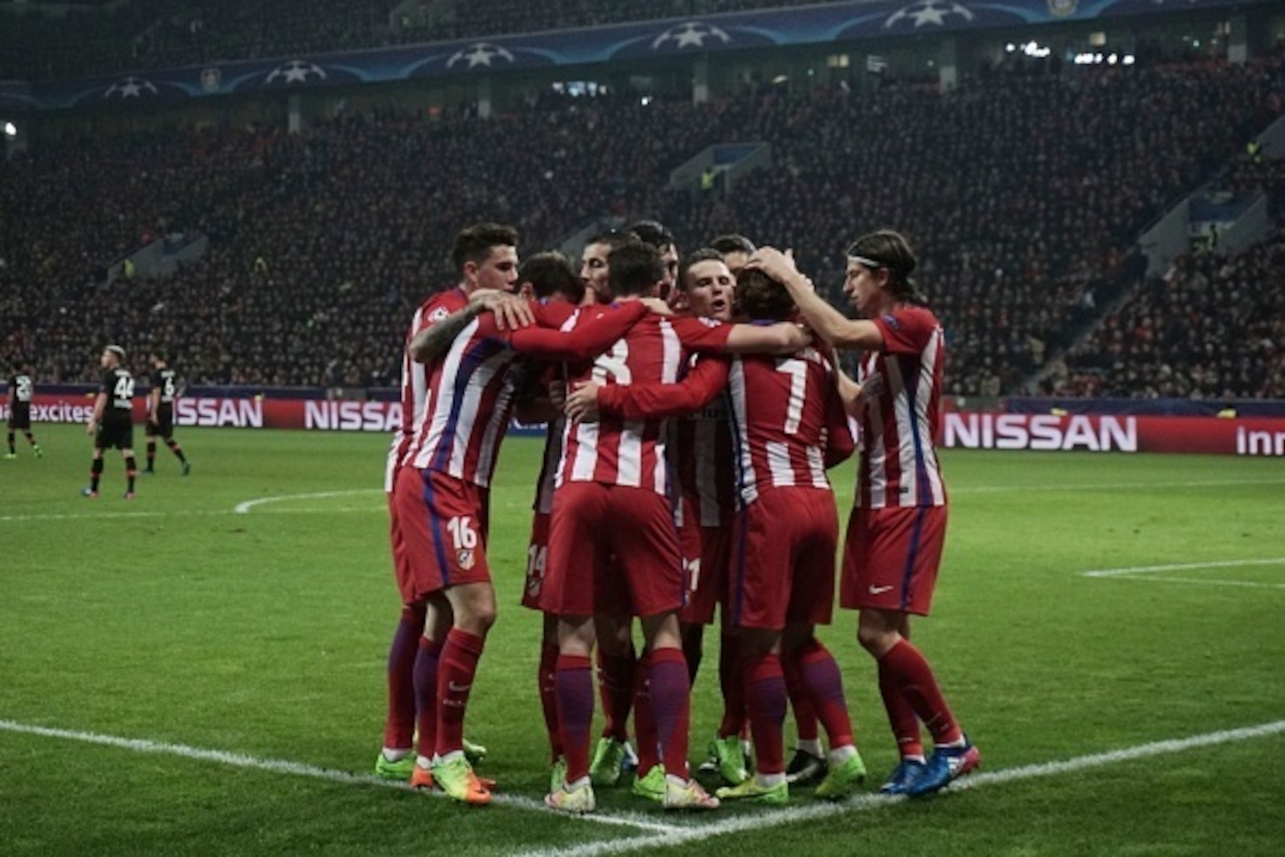 Atletico Madrid's players celebrate after scoring during the UEFA Champions League round of 16 first-leg football match between Bayer 04 Leverkusen and Club Atletico de Madrid in Leverkusen, western Germany on February 21, 2017. / AFP / PATRIK STOLLARZ   
