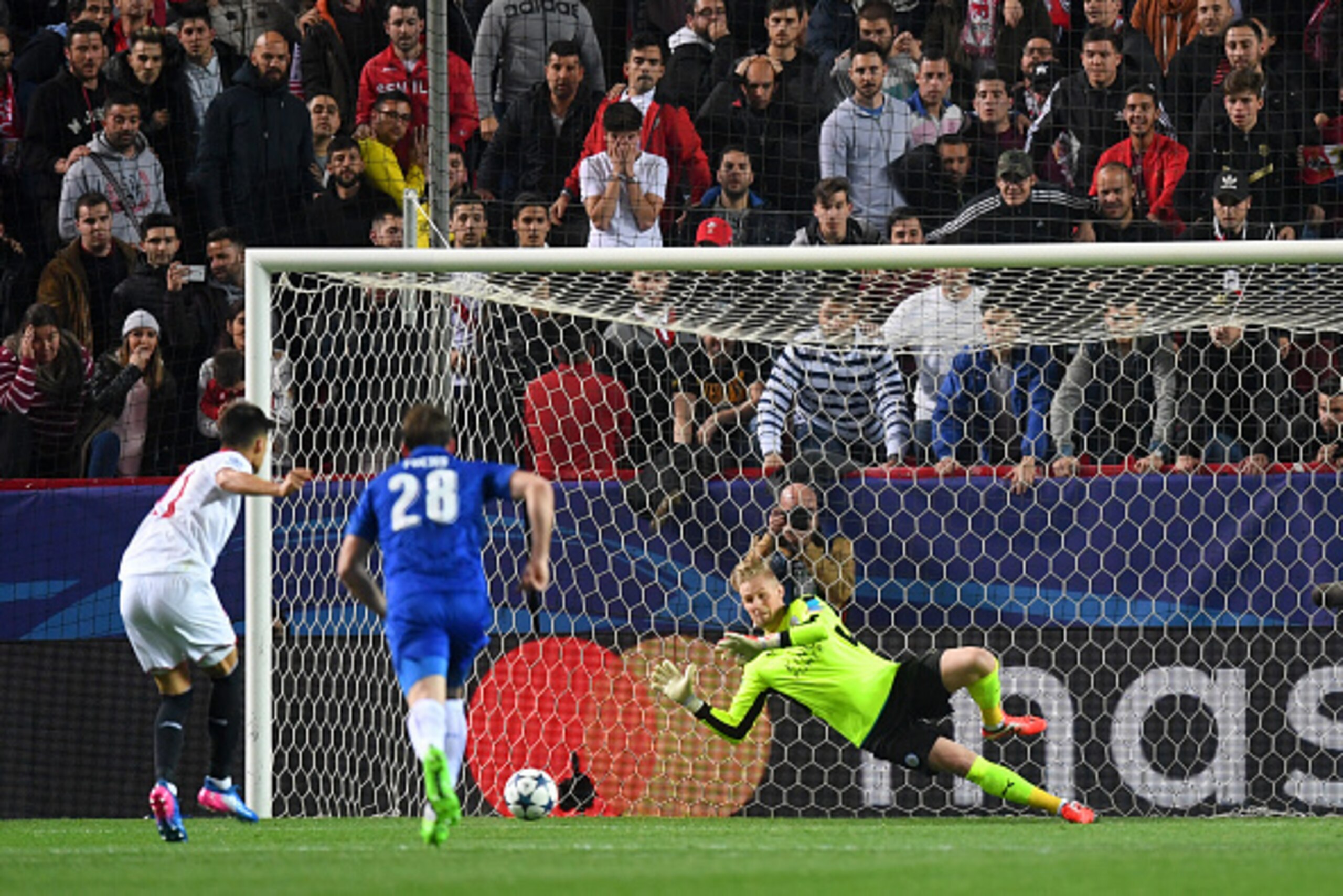 SEVILLE, SPAIN - FEBRUARY 22:  Kasper Schmeichel of Leicester City saves a penalty from Joaquin Correa of Sevilla during the UEFA Champions League Round of 16 first leg match between Sevilla FC and Leicester City at Estadio Ramon Sanchez Pizjuan on Februa