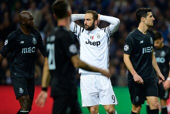 Juventus' Argentinian forward Gonzalo Higuain (C) reacts after missing a chance to score a goal next to Porto's midfielder Danilo Pereira (L) and Spanish defender Ivan Marcano (R) during the UEFA Champions League round of 16 second leg football match FC P
