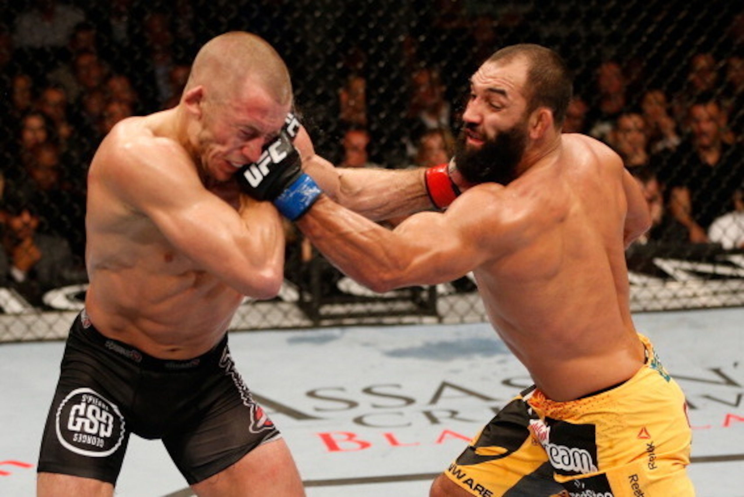 LAS VEGAS, NV - NOVEMBER 16:  (R-L) Johny Hendricks punches Georges St-Pierre in their UFC welterweight championship bout during the UFC 167 event inside the MGM Grand Garden Arena on November 16, 2013 in Las Vegas, Nevada. (Photo by Josh Hedges/Zuffa LLC