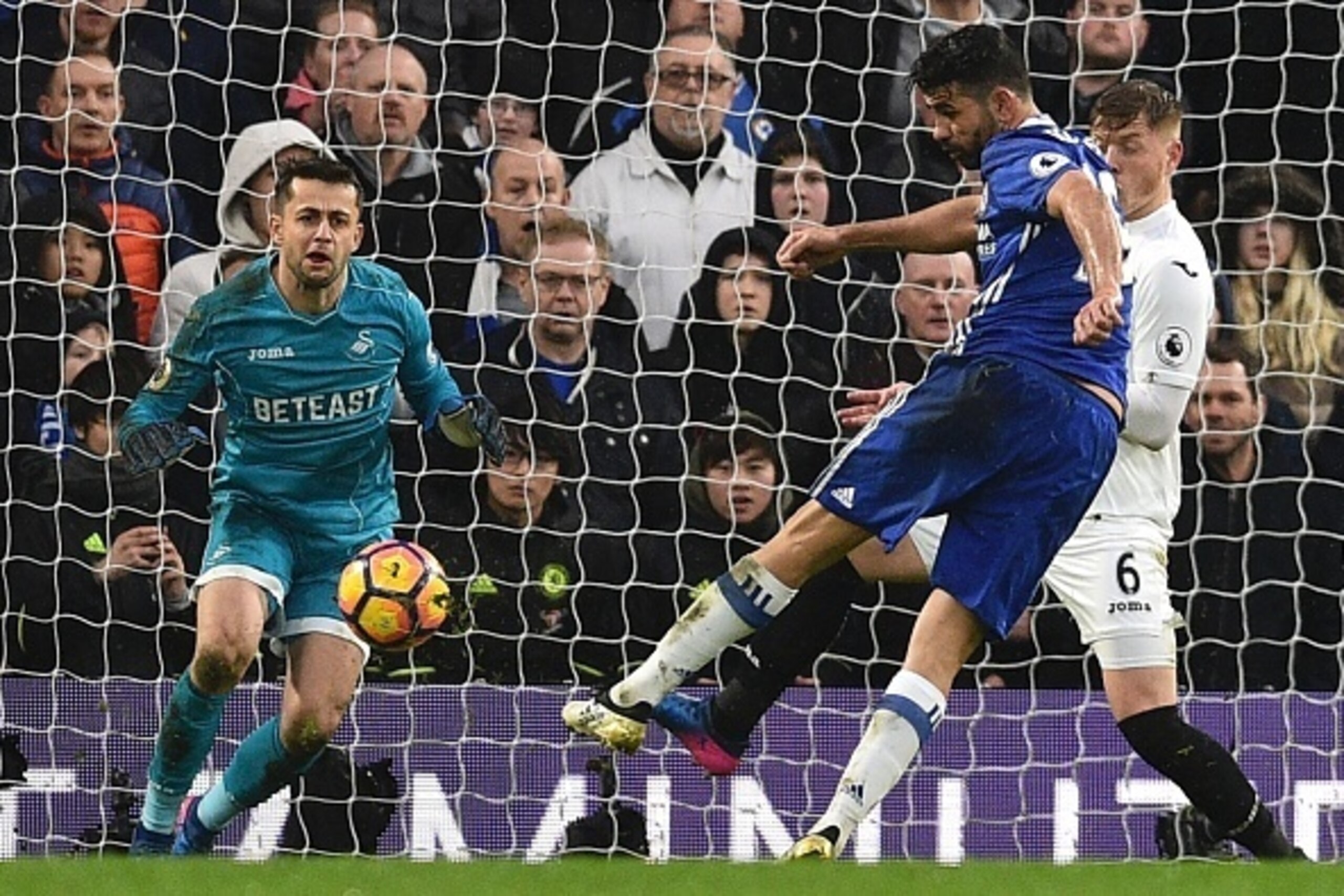 Chelsea's Brazilian-born Spanish striker Diego Costa (R) scores their third goal during the English Premier League football match between Chelsea and Swansea at Stamford Bridge in London on February 25, 2017. / AFP / Glyn KIRK / RESTRICTED TO EDITORIAL US