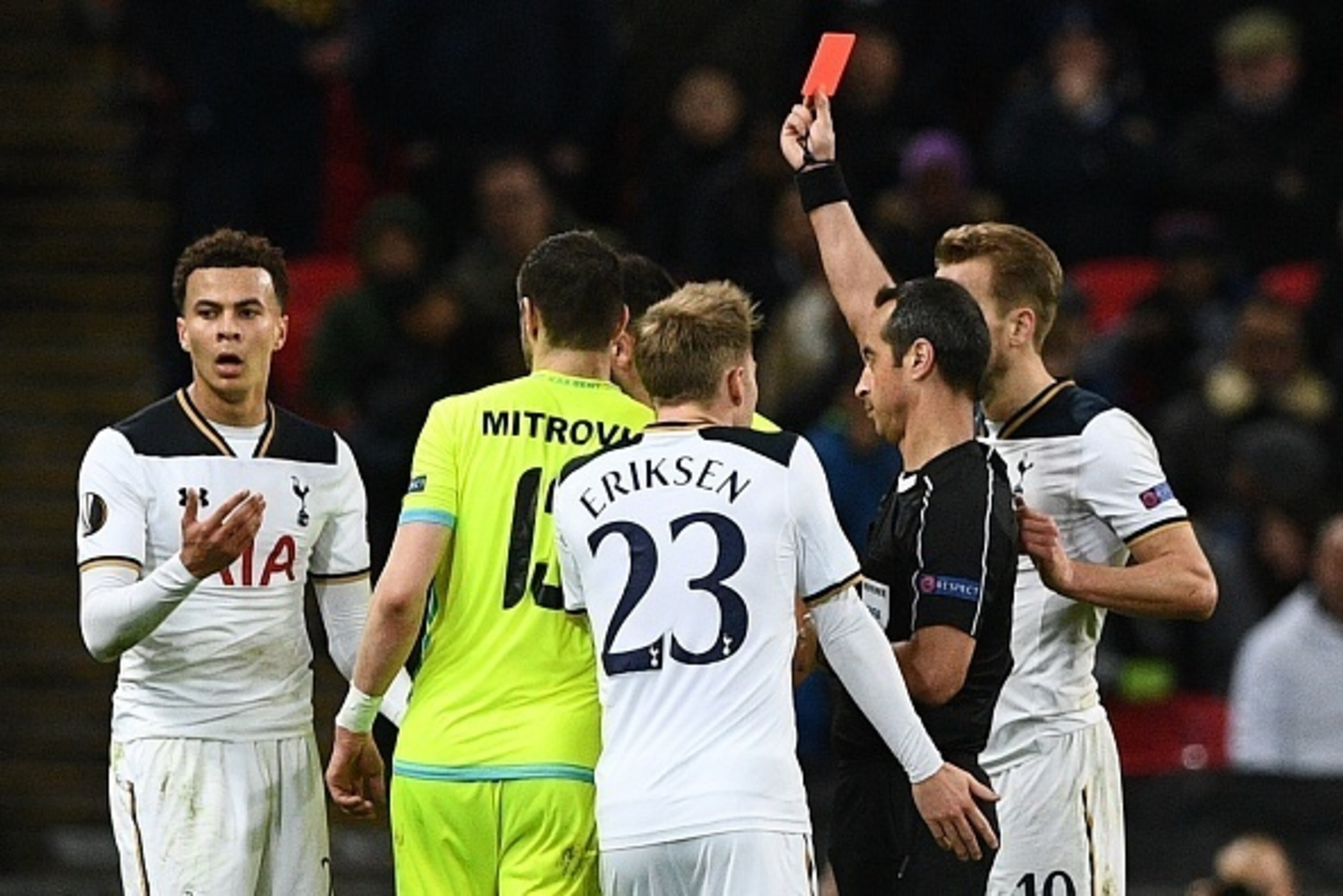 TOPSHOT - Portuguese referee Jorge Sousa (R) shows a straight red card to send off Tottenham Hotspur's English midfielder Dele Alli (L) during the UEFA Europa League Round of 32 second-leg football match between Tottenham Hotspur and KAA Gent at Wembley S