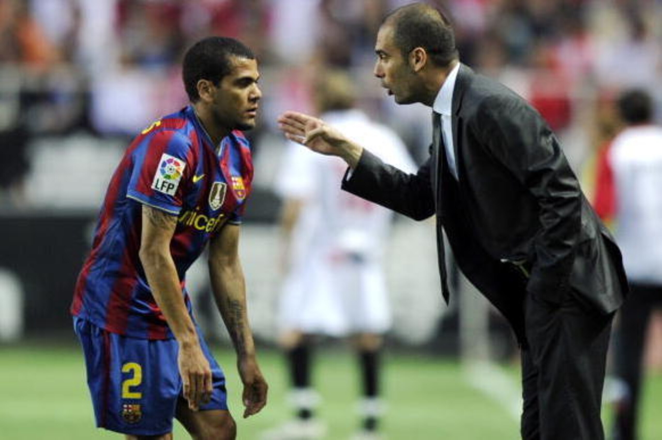 Barcelona's coach Pep Guardiola (R) speaks with Barcelona's Brazilian defender Dani Alves (L) during their Spanish league football match beetwen Sevilla and Barcelona at Sanchez Pizjuan stadium in Sevilla on May 8, 2010. AFP PHOTO / JAVIER SORIANO (Photo 
