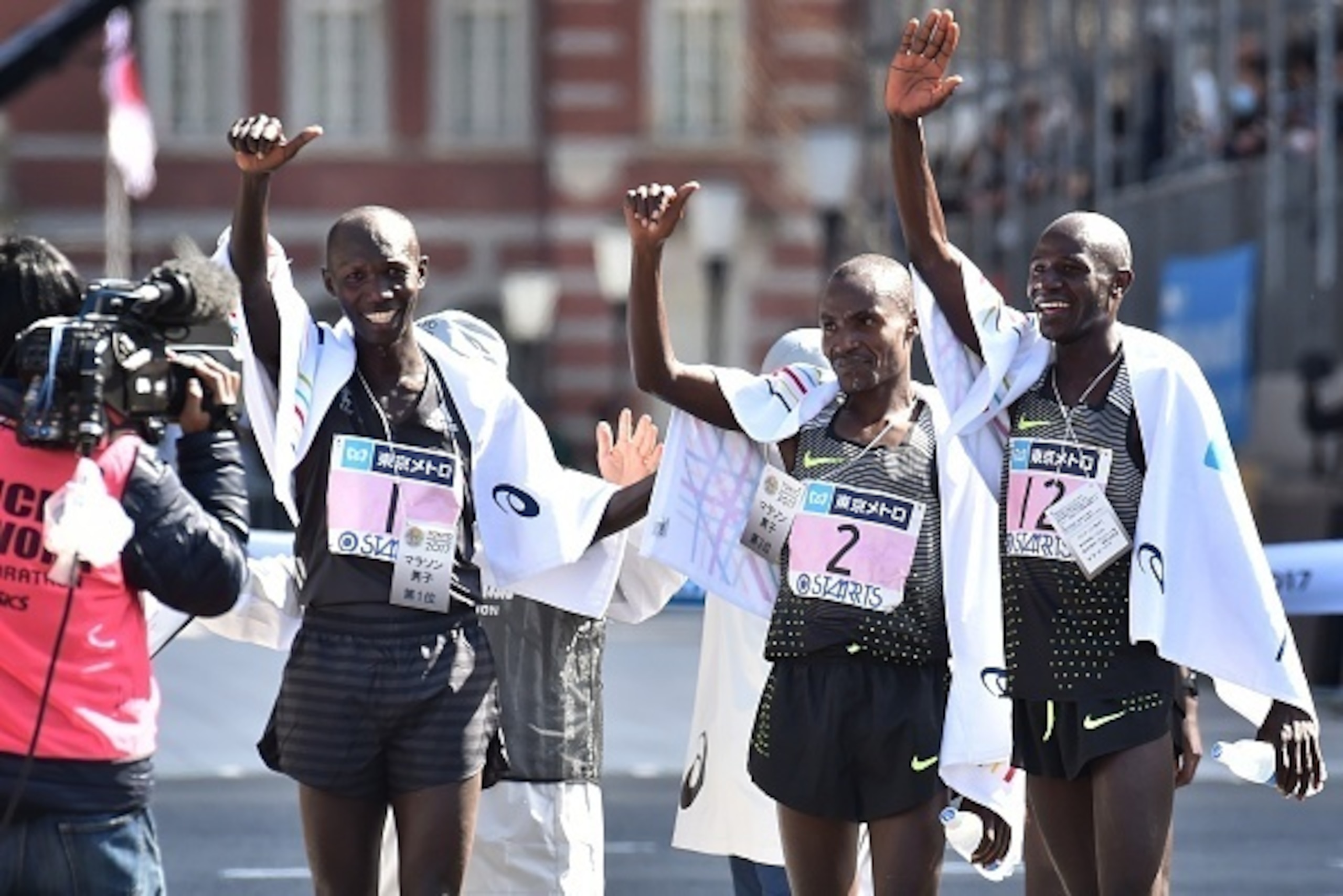 Kenya's Wilson Kipsang (L,#1), compatriots Dickson Chumba (C,#2) and Gideon Kipketer (R, #12) celebrate after crossing the finish line in the men's category of the Tokyo Marathon in Tokyo on February 26, 2017. / AFP / KAZUHIRO NOGI        (Photo credit sh