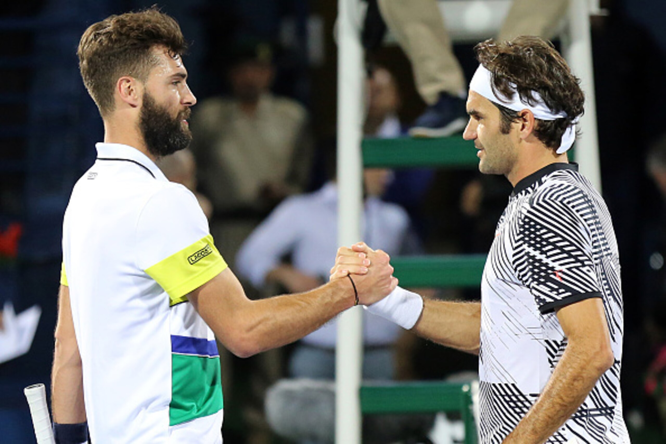 Roger Federer of Switzerland (R) shakes hands with France's Benoit Paire after winning their ATP tennis match during the Dubai Duty Free Championships on February 27, 2017.
 / AFP / MAHMOUD KHALED        (Photo credit should read MAHMOUD KHALED/AFP/Getty 