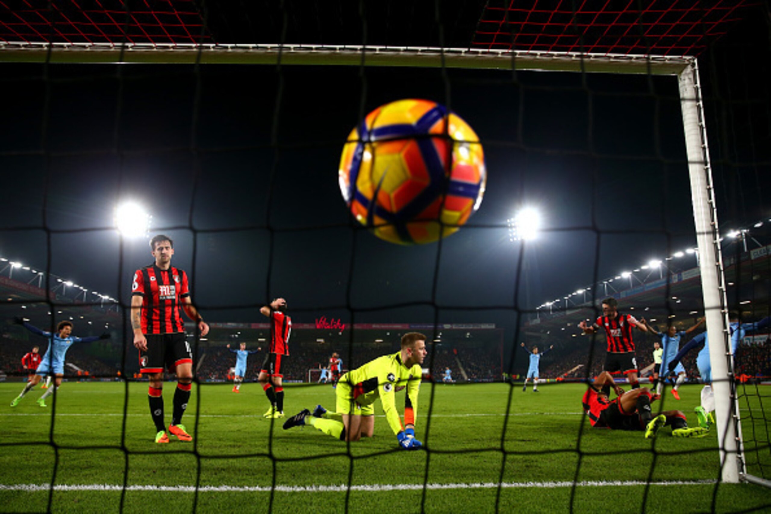BOURNEMOUTH, ENGLAND - FEBRUARY 13:  Sergio Aguero of Manchester City slides in next to Tyrone Mings of Bournemouth to score his team's second goal past Artur Boruc of Bournemouth during the Premier League match between AFC Bournemouth and Manchester City