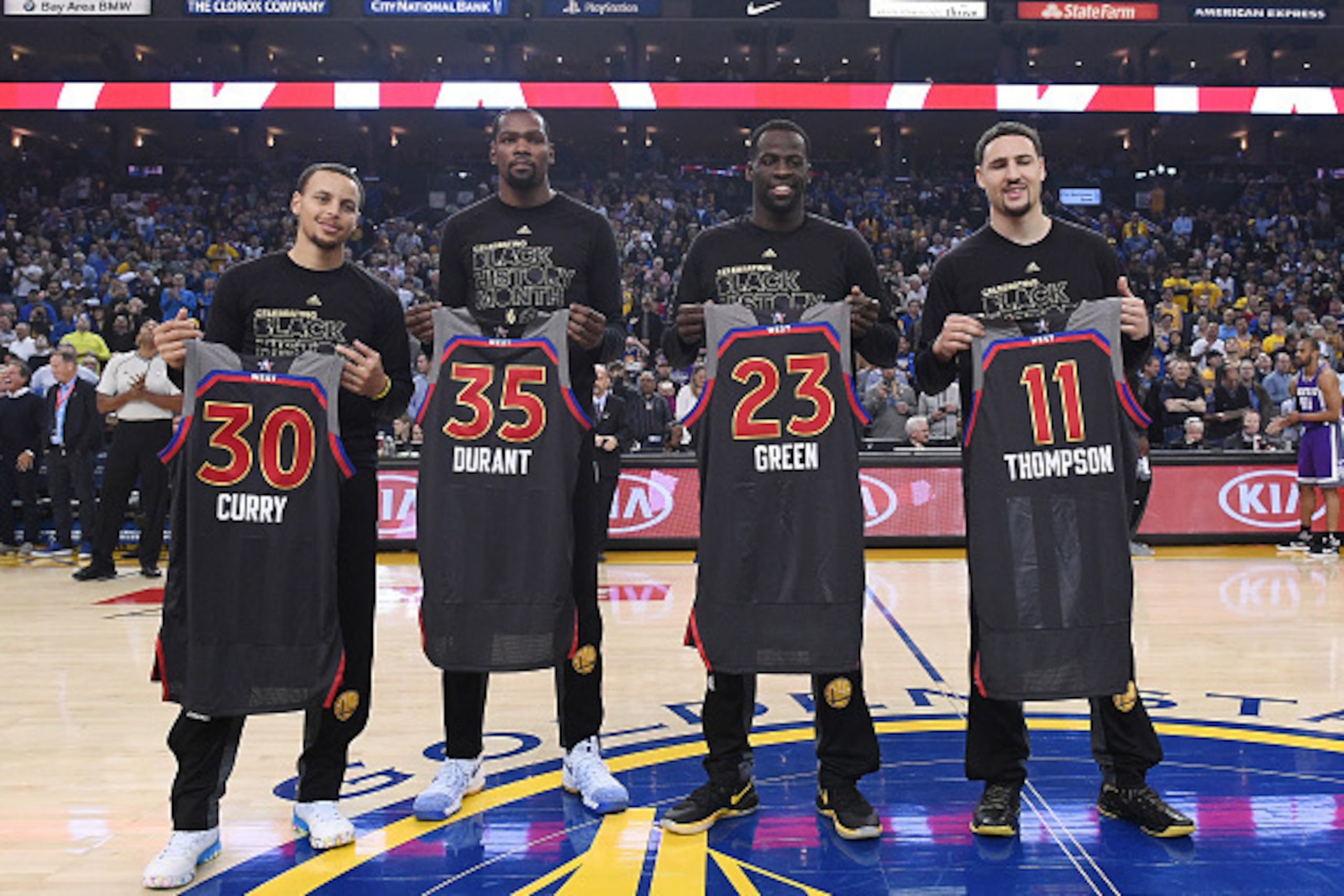 OAKLAND, CA - FEBRUARY 15:  (L-R) Stephen Curry #30, Kevin Durant #35, Draymond Green #23 and Klay Thompson #11 of the Golden State Warriors display the AllStar Jerseys prior to the start of an NBA Basketball game against the Sacramento Kings at ORACLE Ar