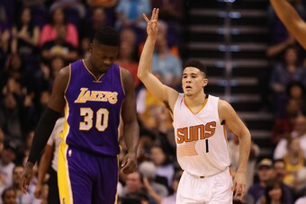 PHOENIX, AZ - FEBRUARY 15:  Devin Booker #1 of the Phoenix Suns reacts to a three point shot ahead of Julius Randle #30 of the Los Angeles Lakers during the first half of the NBA game at Talking Stick Resort Arena on February 15, 2017 in Phoenix, Arizona.