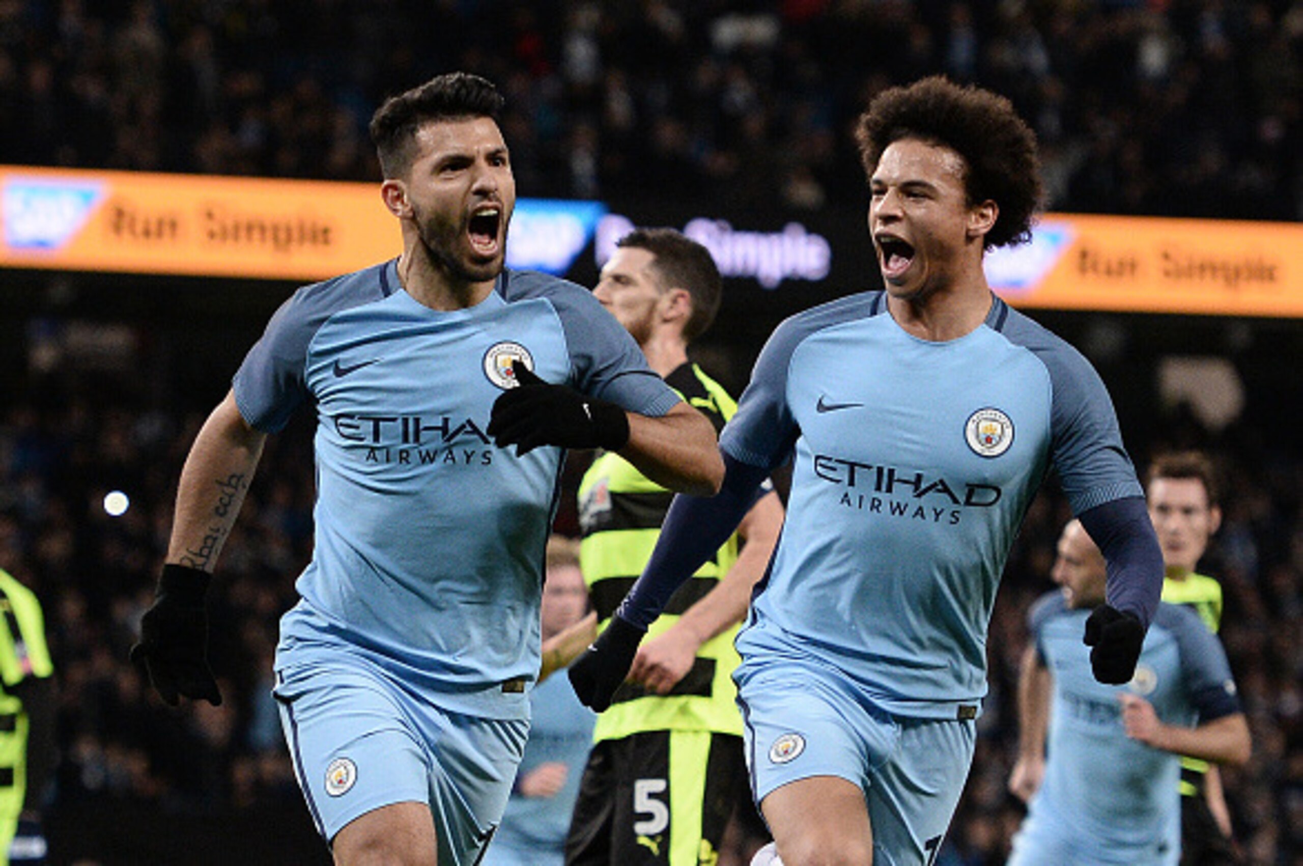 Manchester City's Argentinian striker Sergio Aguero (L) celebrates scoring his team's second goal with Manchester City's German midfielder Leroy Sane during the FA Cup fourth round replay football match between Manchester City and Huddersfield Town at the