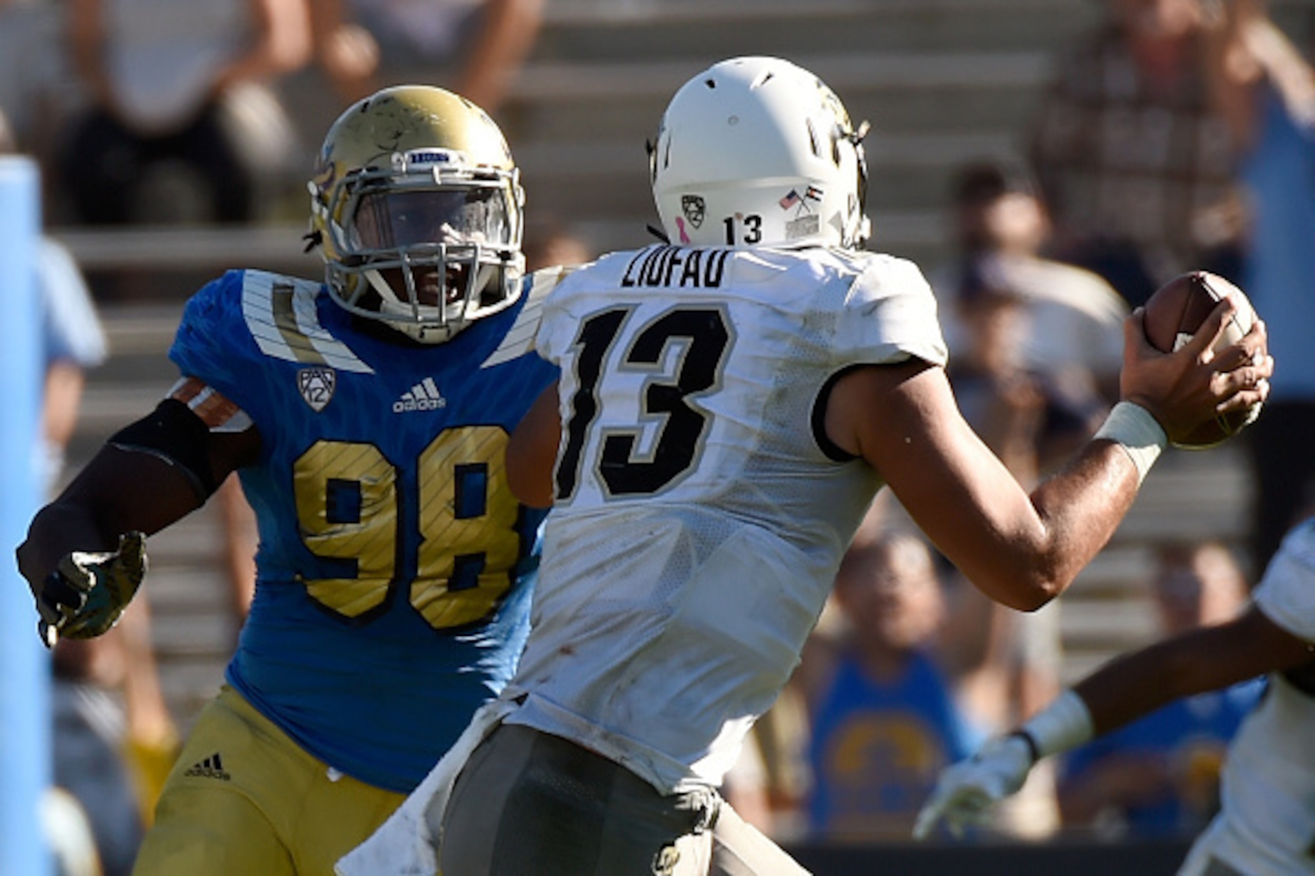 PASADENA, CA - OCTOBER 31:  (Left) Takkarist McKinley #98 of the UCLA Bruins plays defense against quarterback Serfo Liufau #13 the Colorado Buffaloes in the fourth quarter at Rose Bowl on October 31, 2015 in Pasadena, California.  (Photo by Lisa Blumenfe